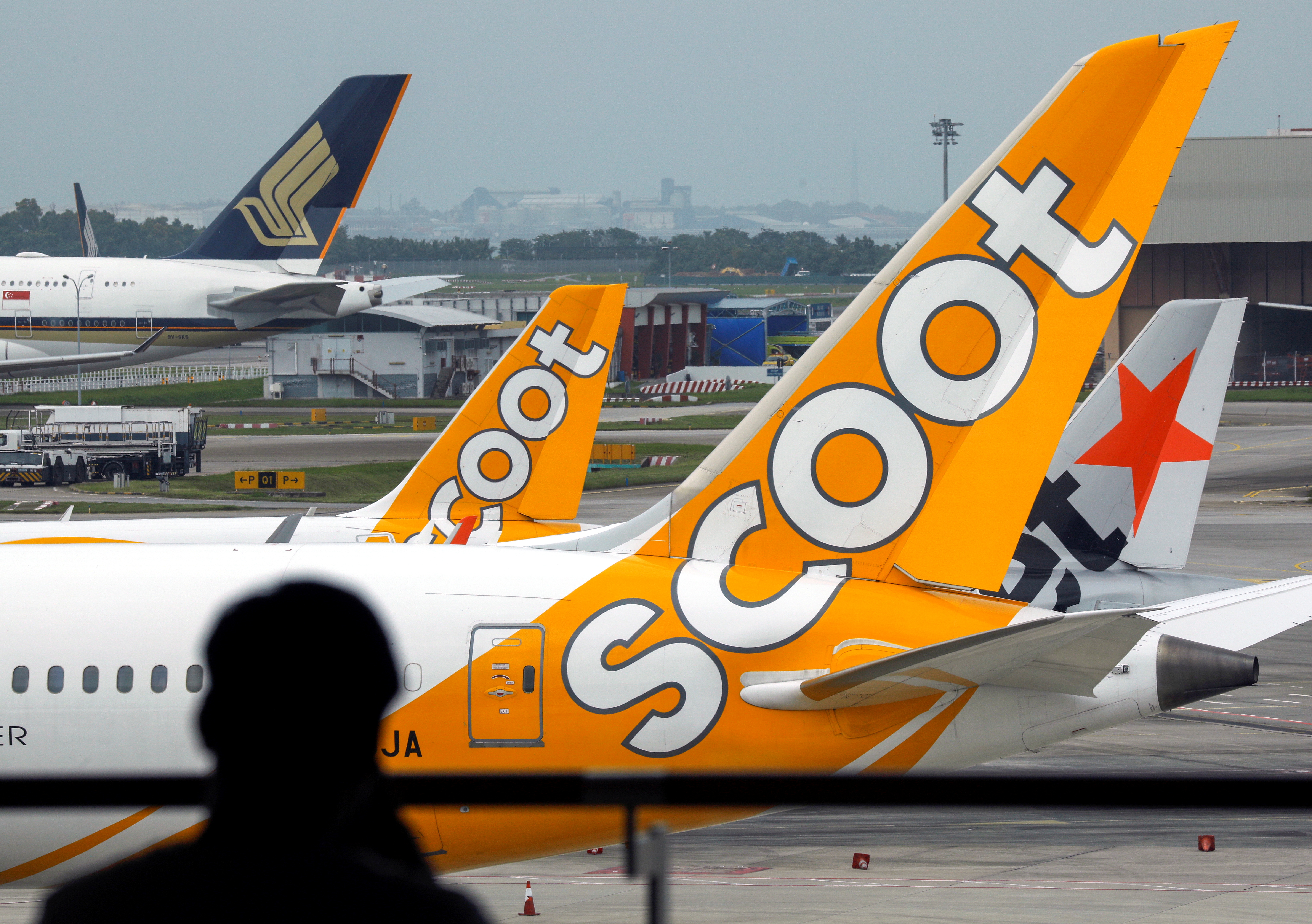Scoot, Jetstar and Singapore Airlines planes sit on the tarmac at Singapore's Changi Airport