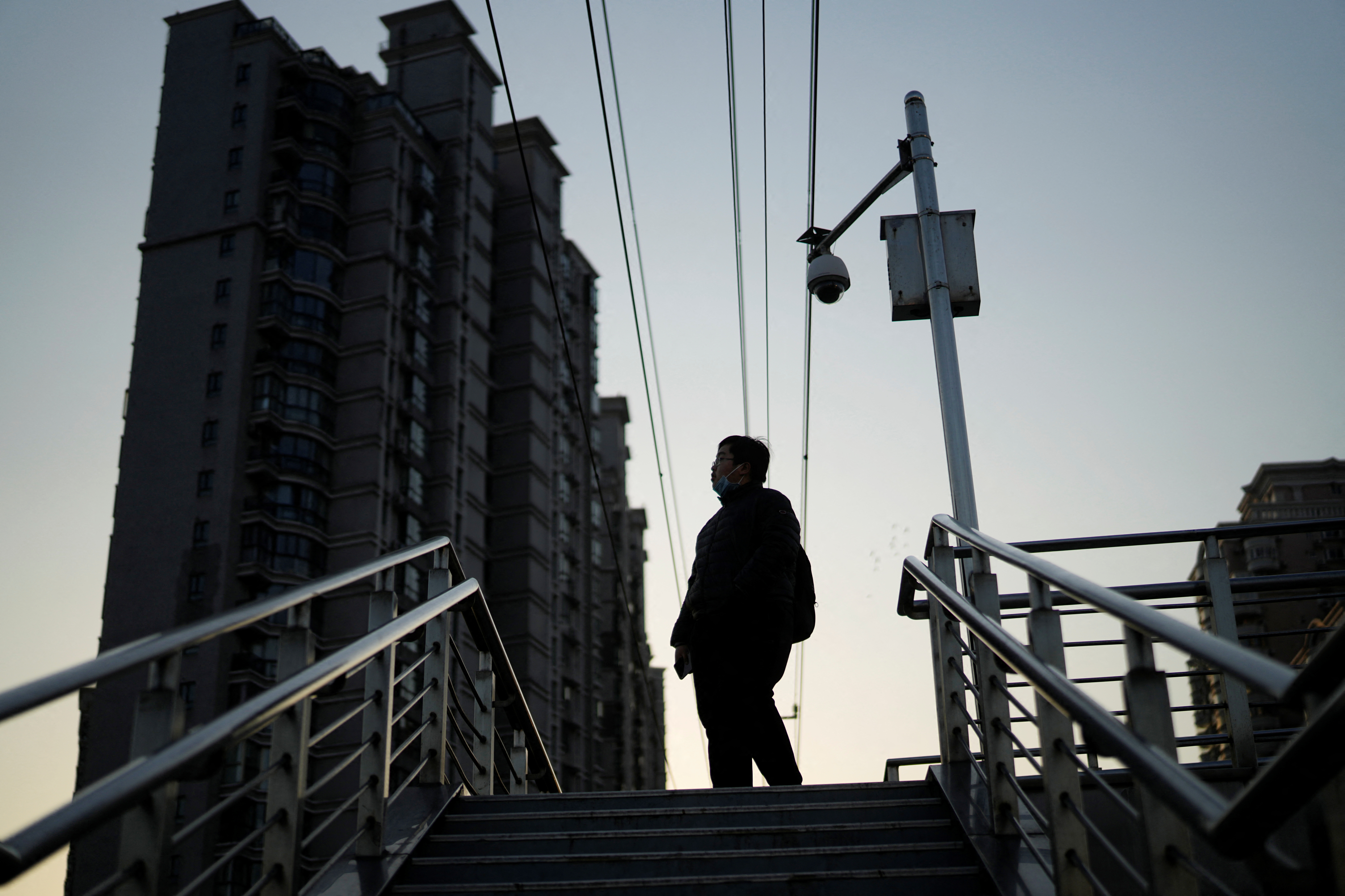 Pedestrian walks on an overpass near residential buildings in Shanghai
