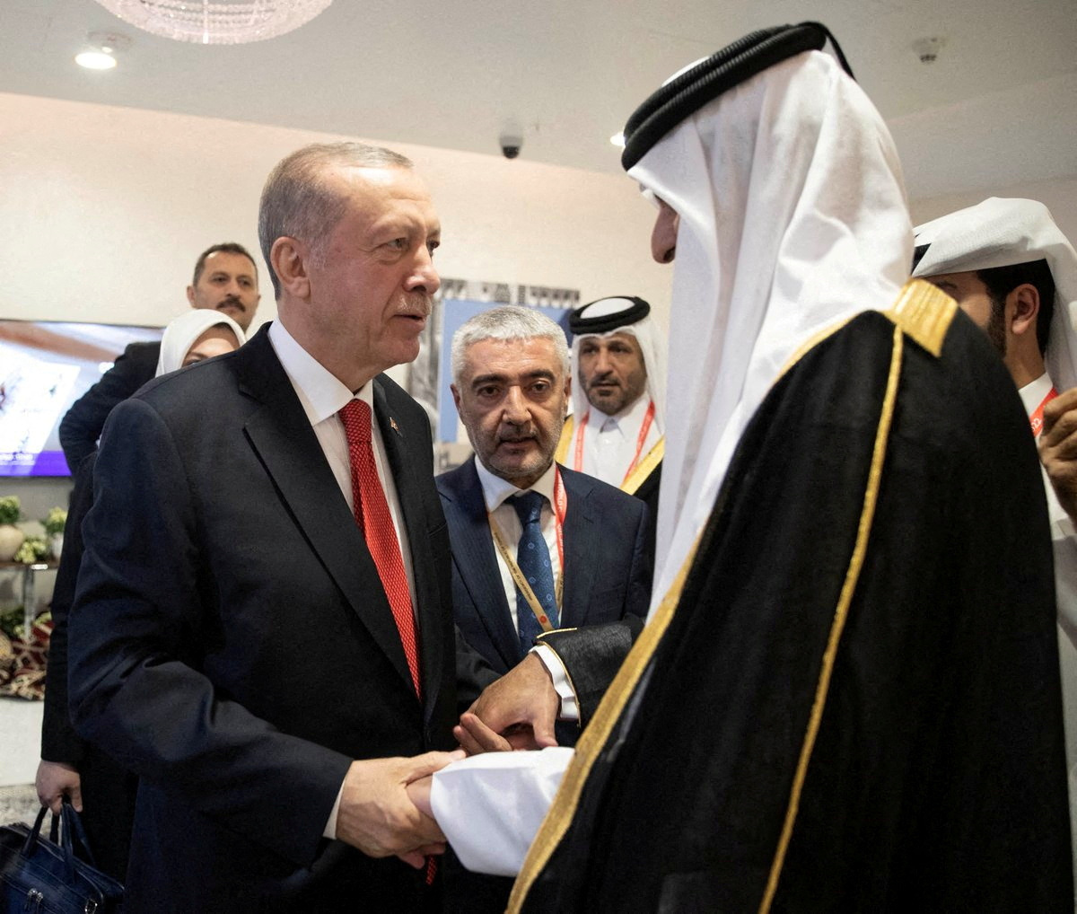 Turkey's President Tayyip Erdogan shakes hands with Qatari Emir Sheikh Tamim bin Hamad al-Thani on the sidelines of the World Cup in Doha