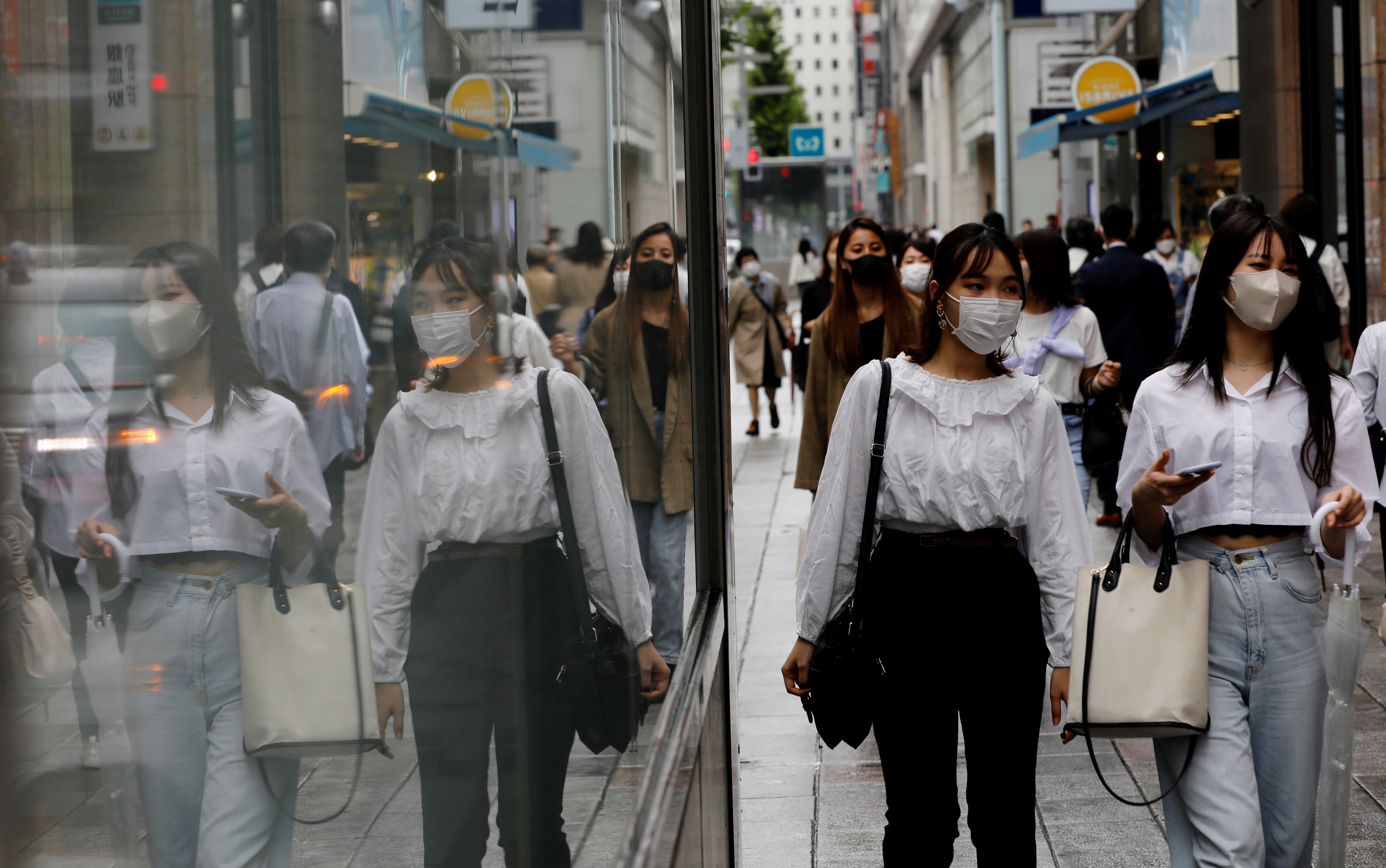 People wearing protective masks in a shopping district in Tokyo,