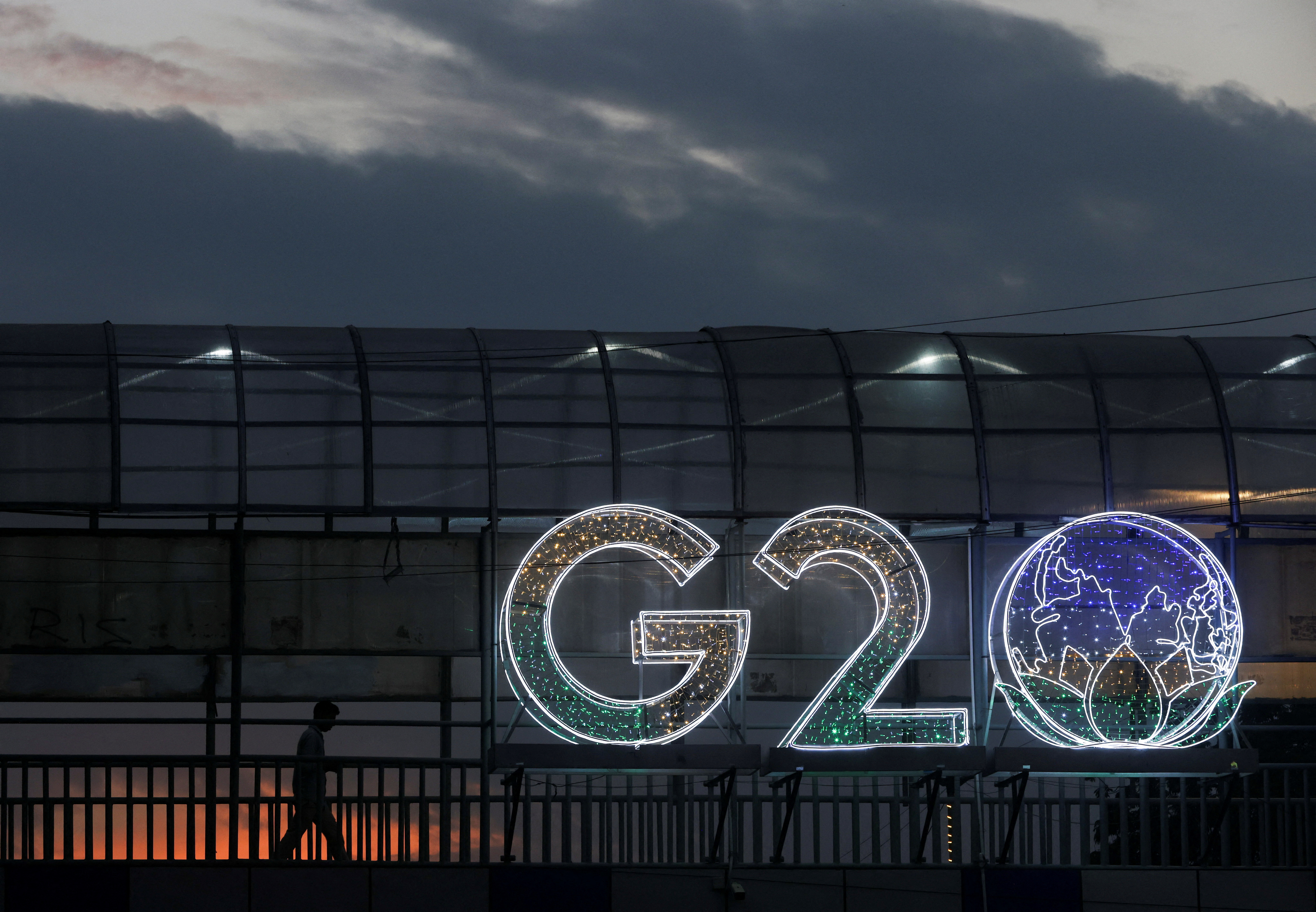 A man walks past an installation on a skywalk ahead of the G20 Summit in New Delhi