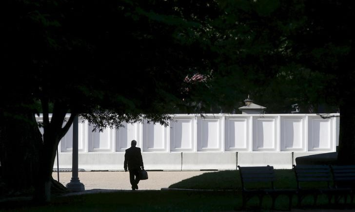 A man carrying a briefcase makes his way through Lafayette Park near the White House in Washington