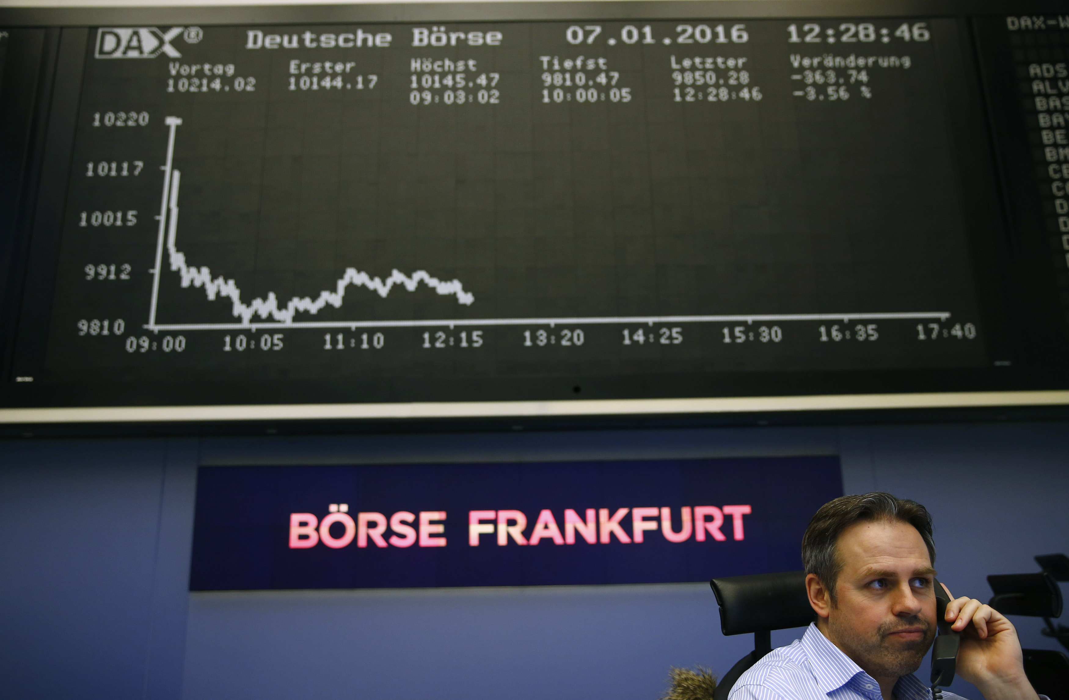 Trader speaks on phone in front of DAX board at Frankfurt's stock exchange