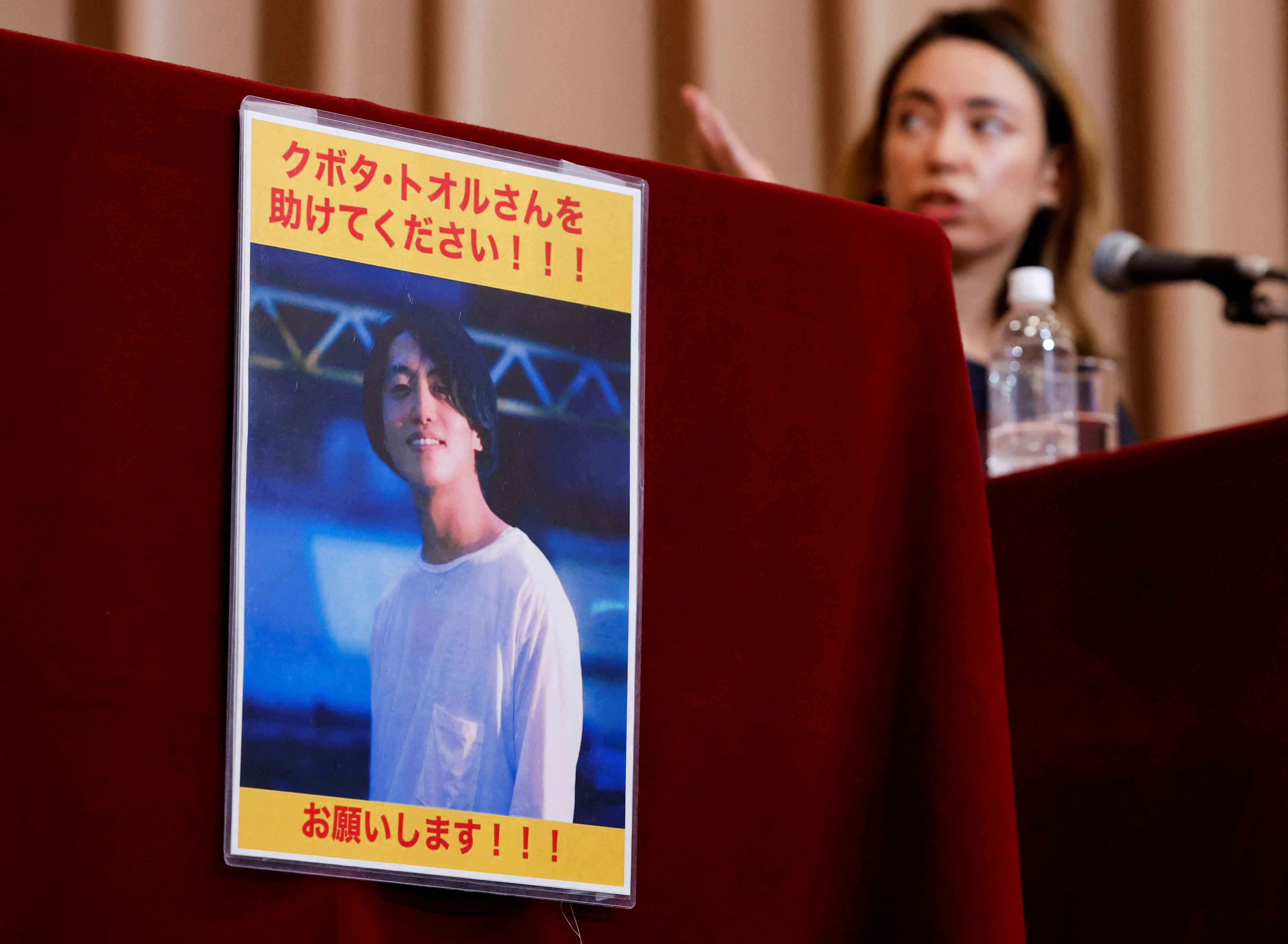 A portrait photo of Japanese documentary filmmaker Toru Kubota, who has been detained in Myanmar, is displayed during a news conference in Tokyo