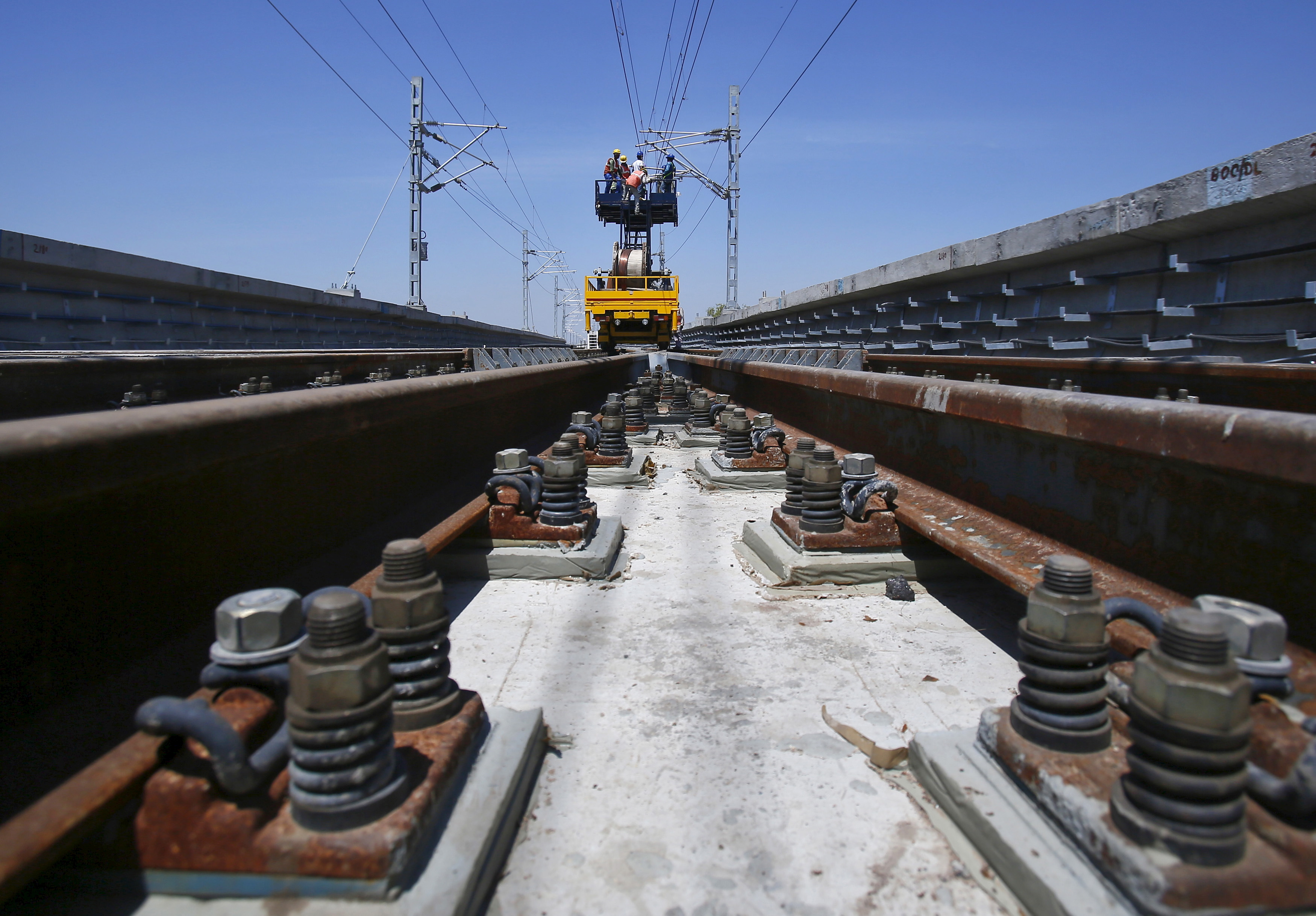 DMRC workers install copper wires at the construction site of Ajronda station, outskirts of New Delhi