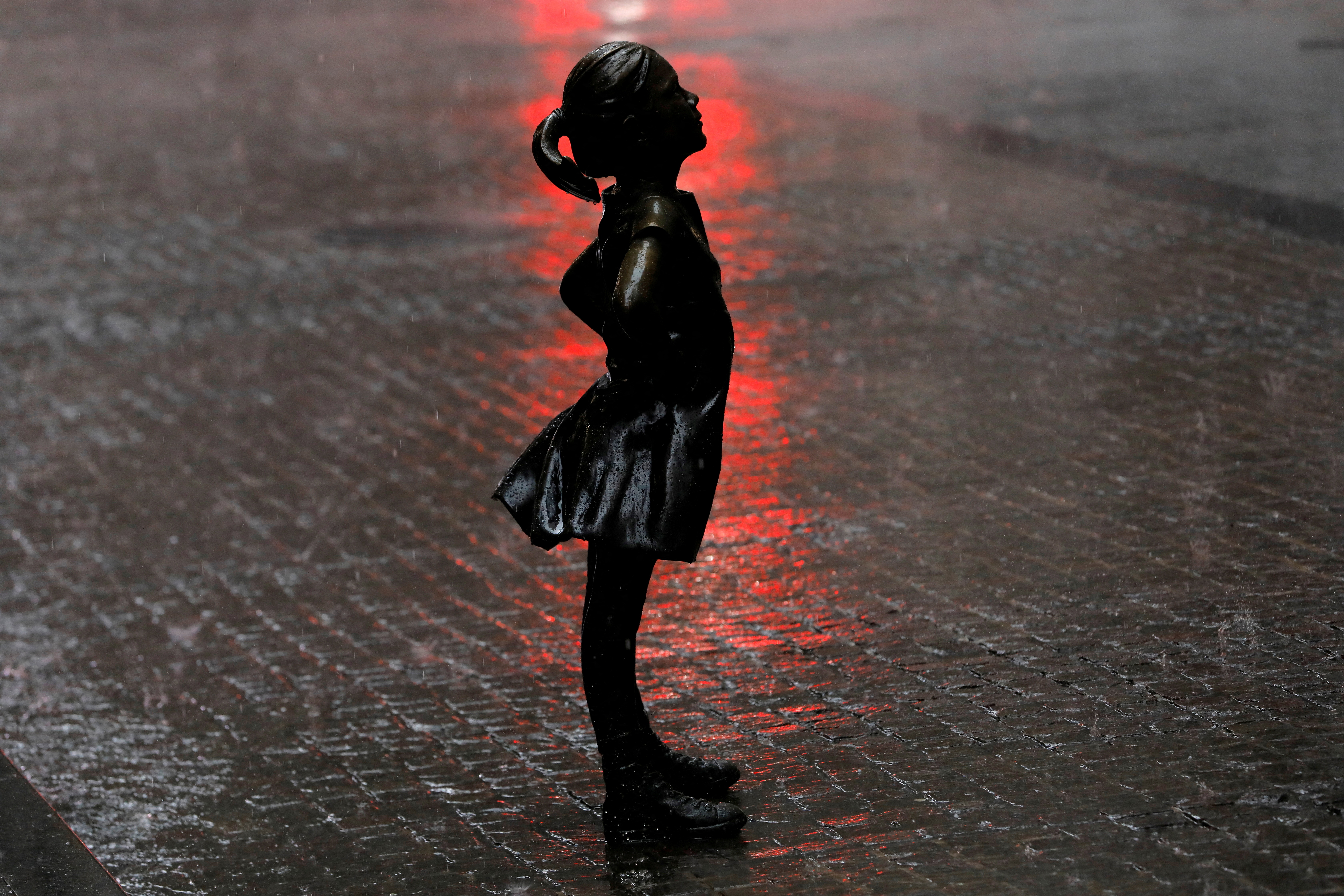 The Fearless Girl statue is seen while heavy rain falls as a severe weather system passes through the area in the Manhattan borough of New York City