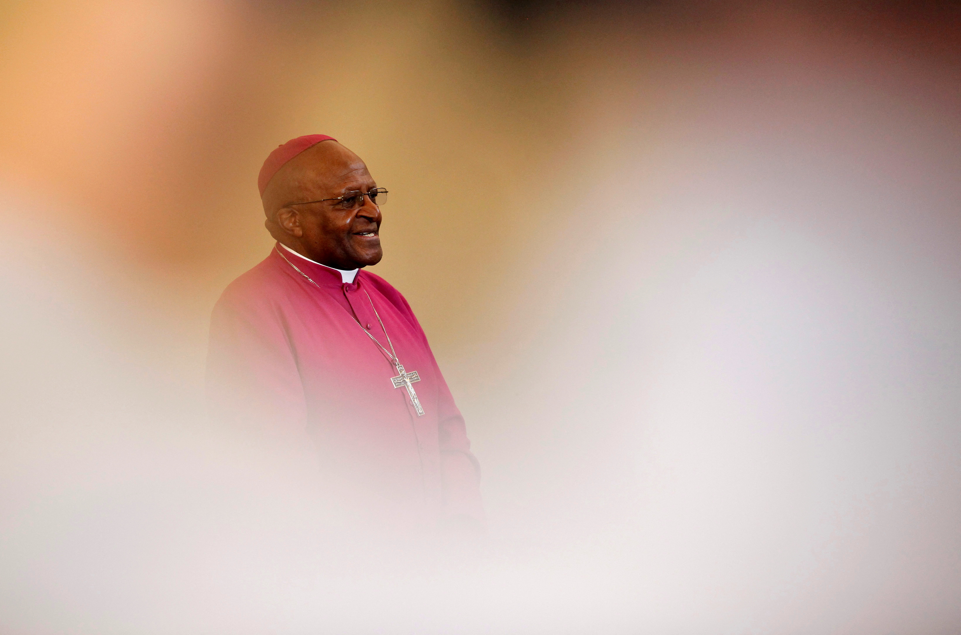 Archbishop Desmond Tutu is seen through crowds during a visit to a youth centre in Masiphelele township near Cape Town
