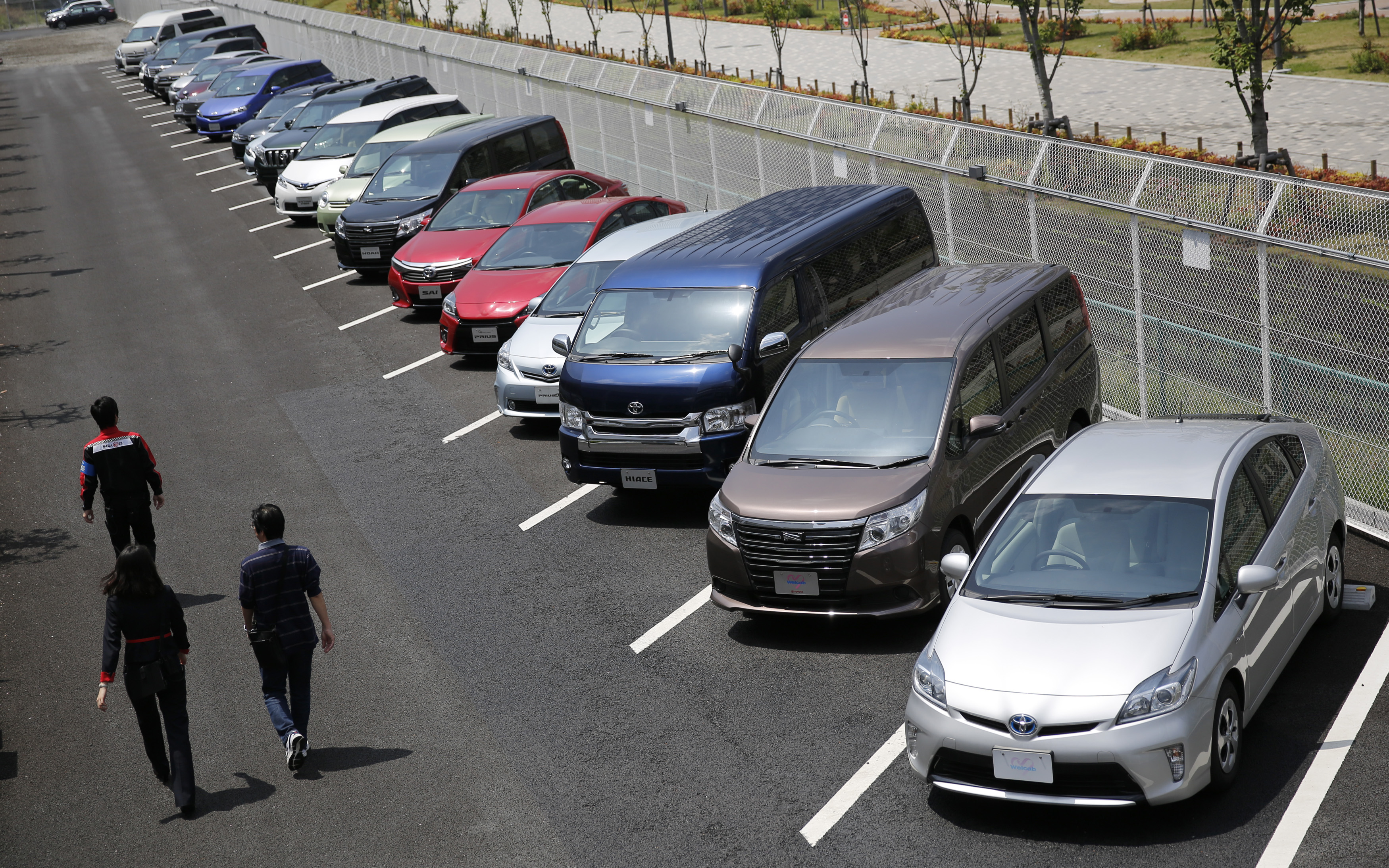 People walk beside test-driving cars outside a car maker's showroom in Tokyo May 1, 2014.  REUTERS/Toru Hanai 