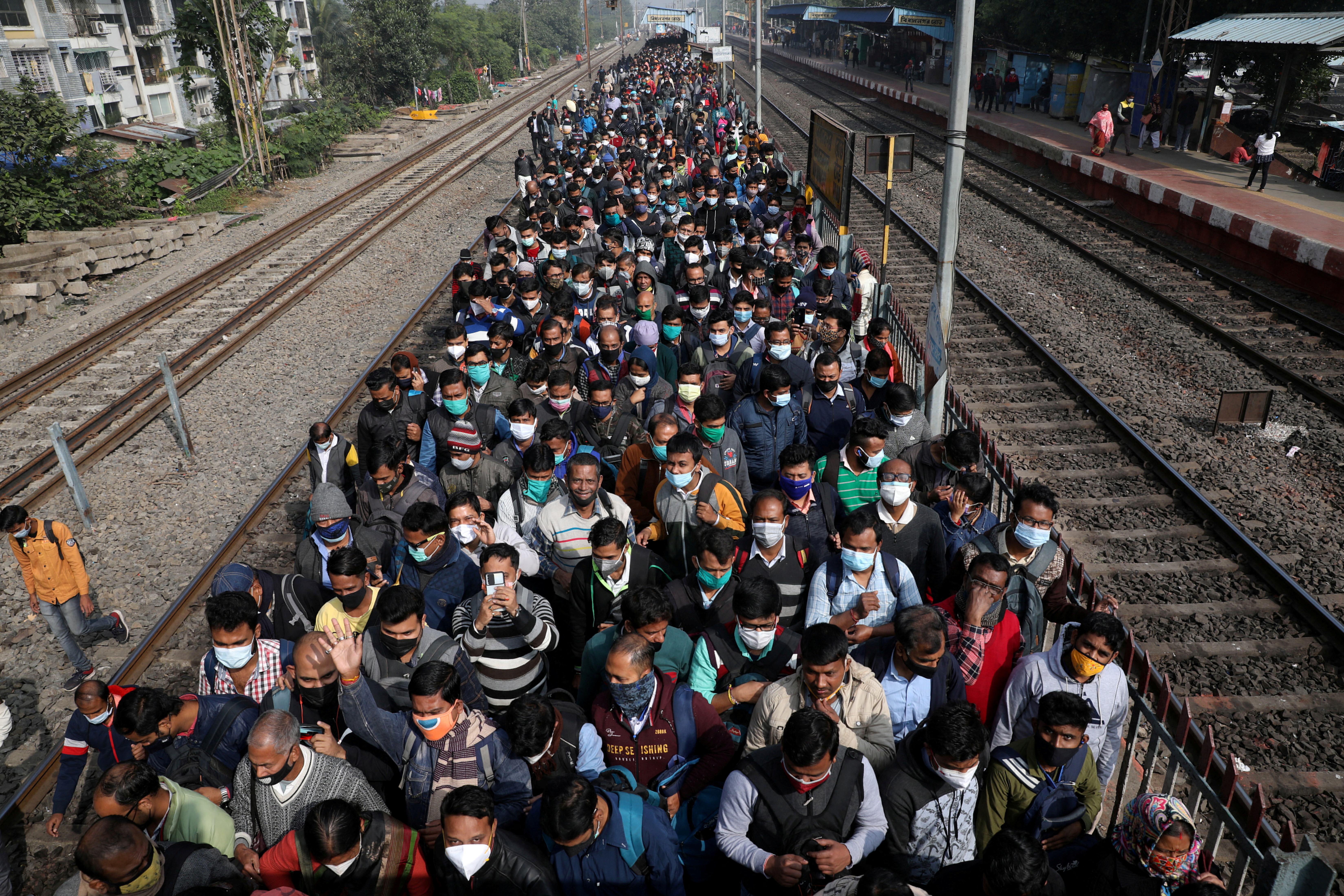 Commuters leave a platform after disembarking from a suburban train on the outskirts of Kolkata