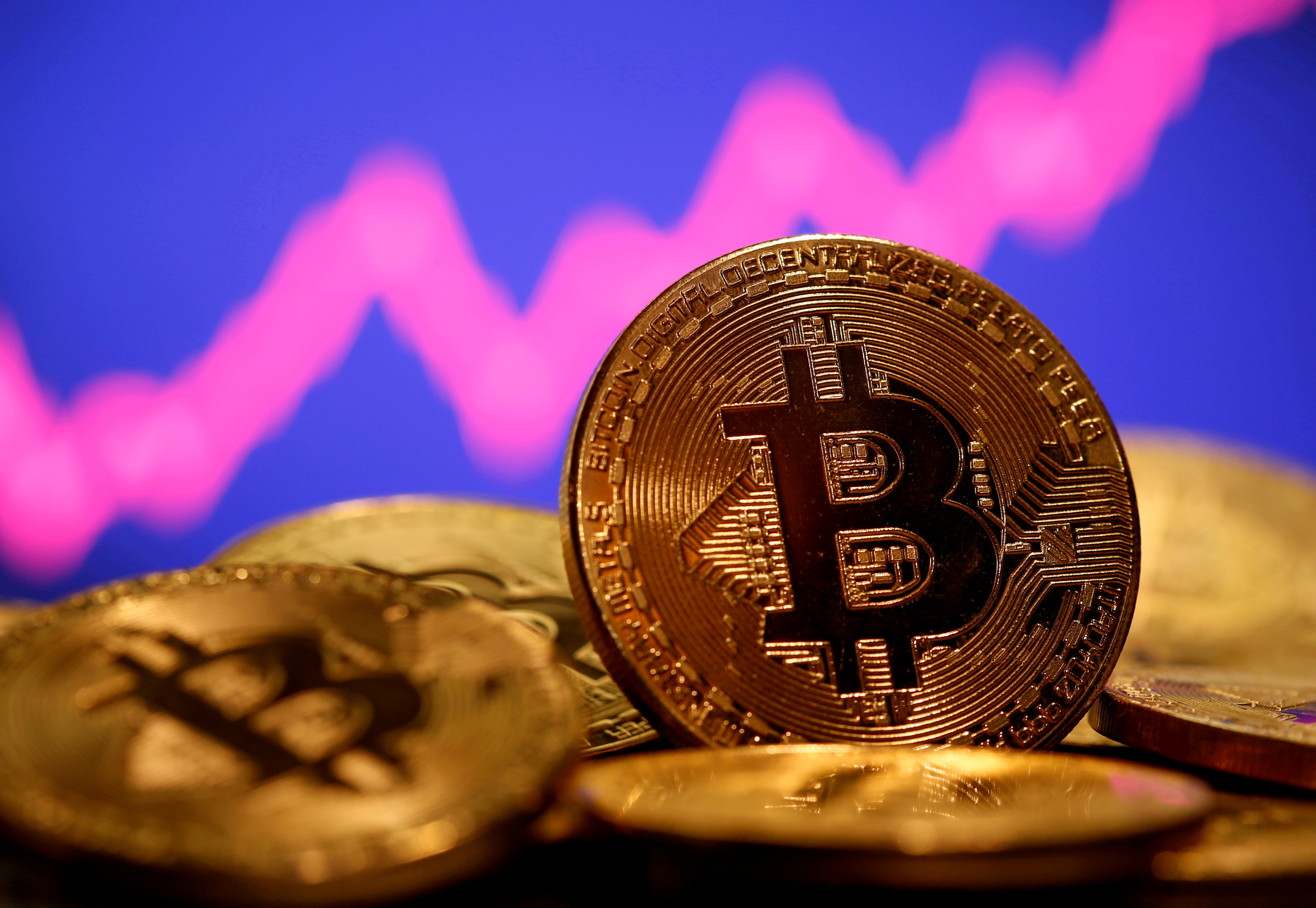 A representation of virtual currency Bitcoin is seen in front of a stock graph in this illustration taken January 8, 2021. REUTERS/Dado Ruvic/File Photo/File Photo