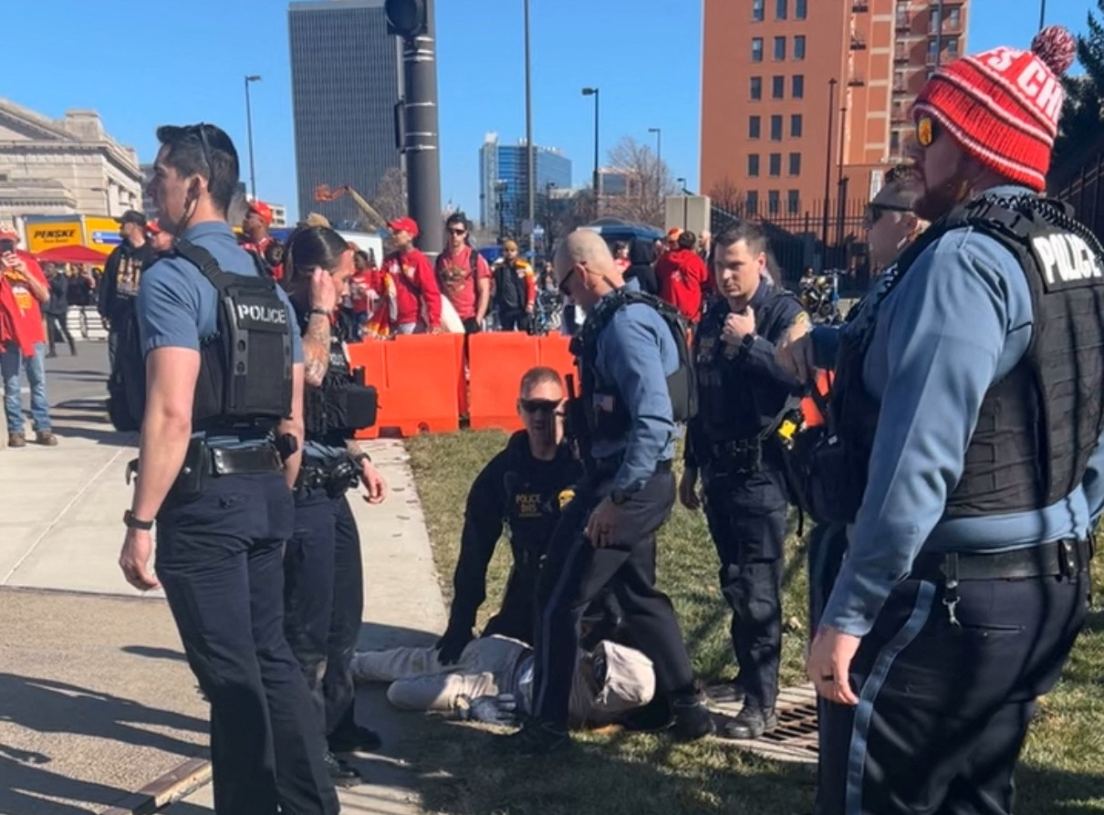 Police detain a person following a shooting near an outdoor celebration of the NFL champion Chiefs' Super Bowl victory, in Kansas City