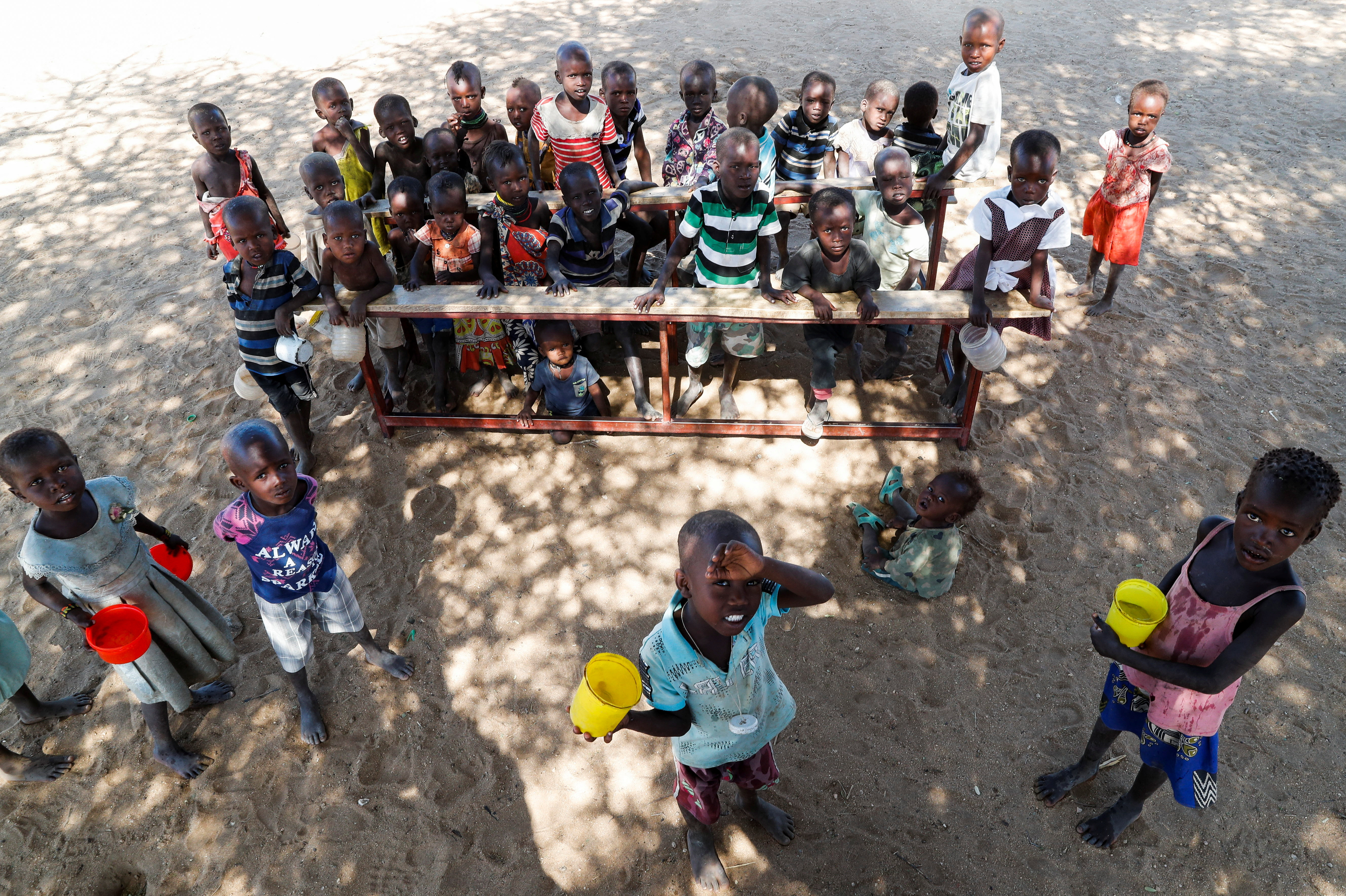 Children from the Turkana pastoralist community affected by the worsening drought due to failed rain seasons, look on at an open classroom under a tree at the Sopel Primary School in Sopel village in Turkana