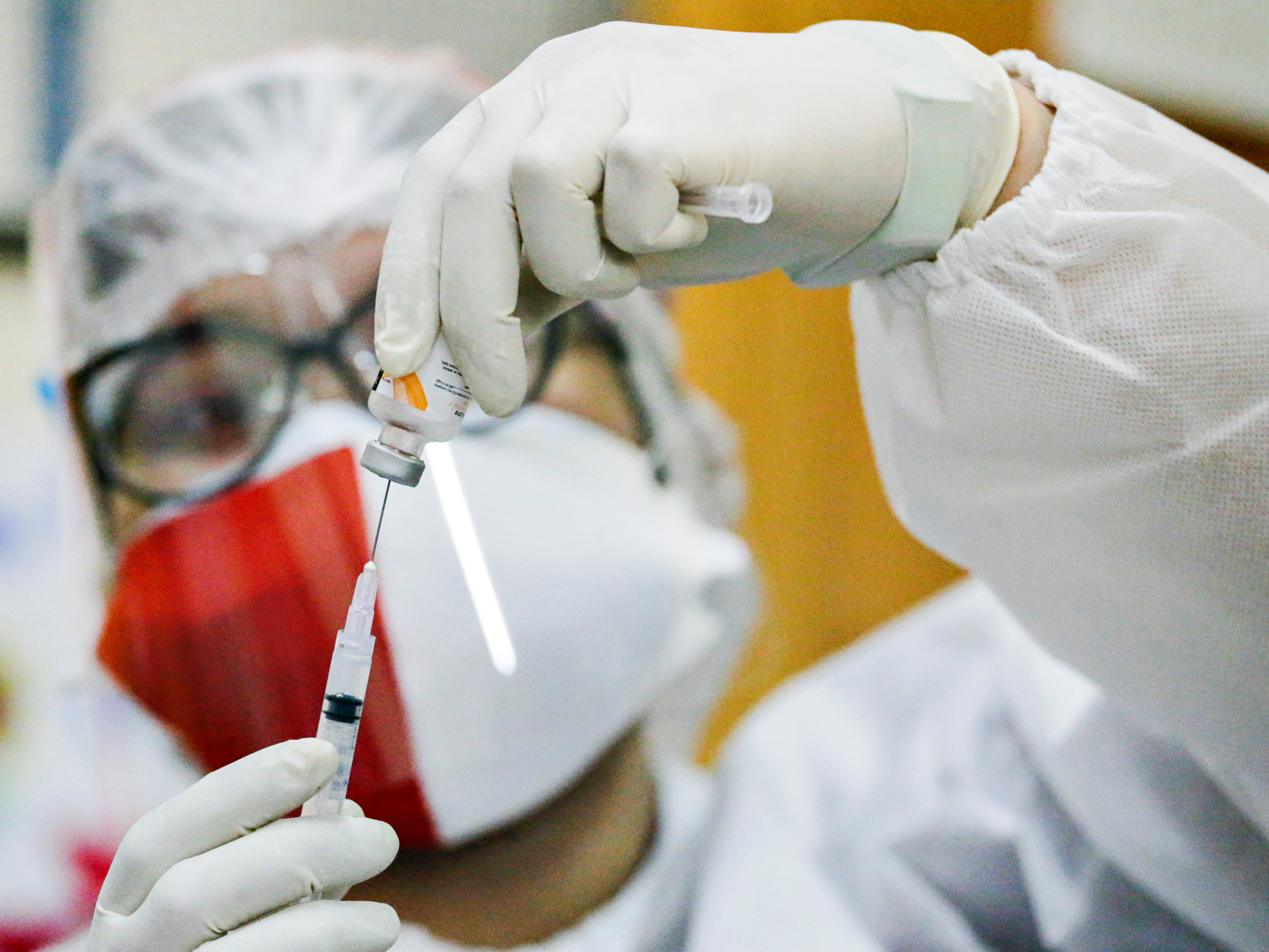 A healthcare worker wearing an Indonesian flag mask to mark the country's 76th Independence Day, prepares a dose of China's Sinovac Biotech vaccine against the coronavirus disease (COVID-19) during a mass vaccination program in Jakarta, Indonesia, August 17, 2021. REUTERS/Ajeng Dinar Ulfiana