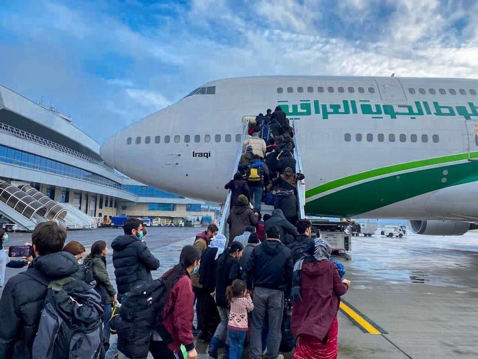 Iraqi migrants board the plane for evacuation flight at Minsk airport, Belarus