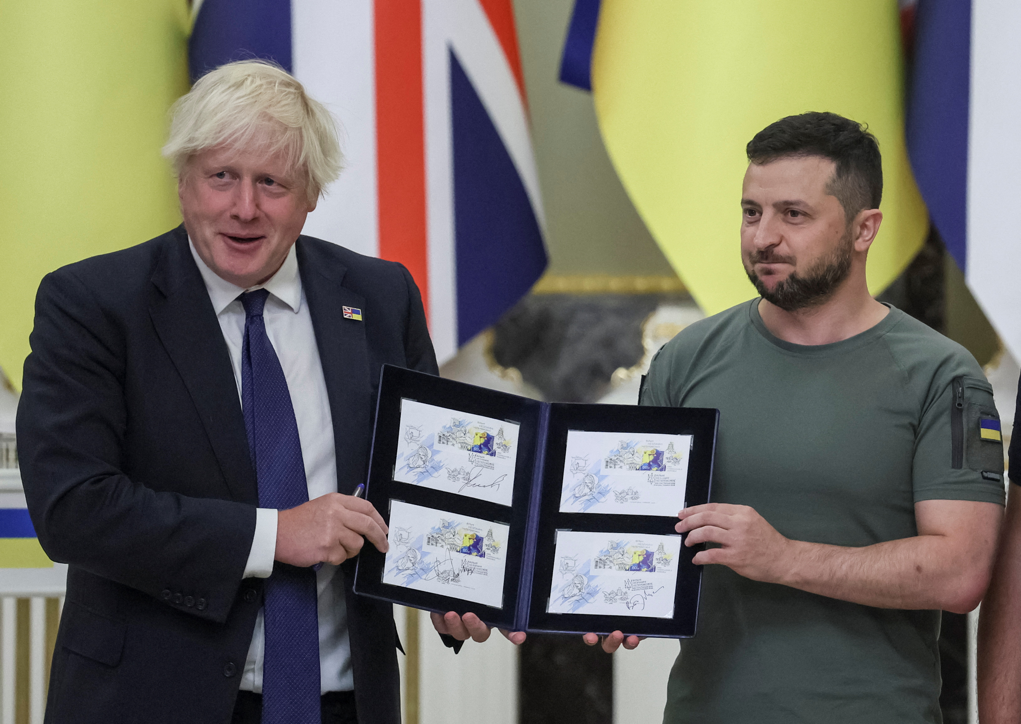 Ukraine's President Zelenskiy and British Prime Minister Johnson hold certified Independence Day postal stamps in Kyiv