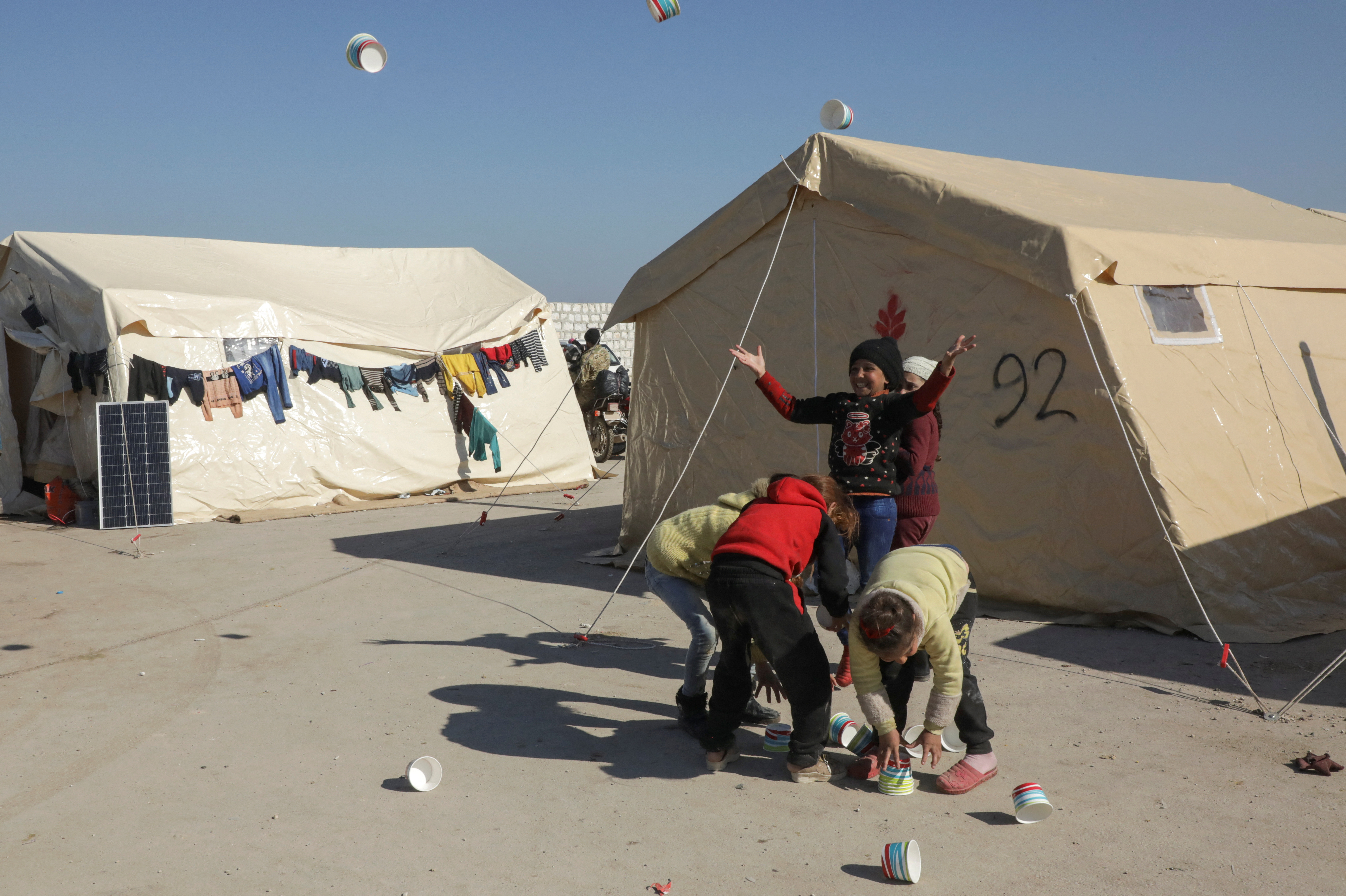 Children play near tents at a camp for earthquake survivors, on the outskirts of rebel-held town of Jandaris
