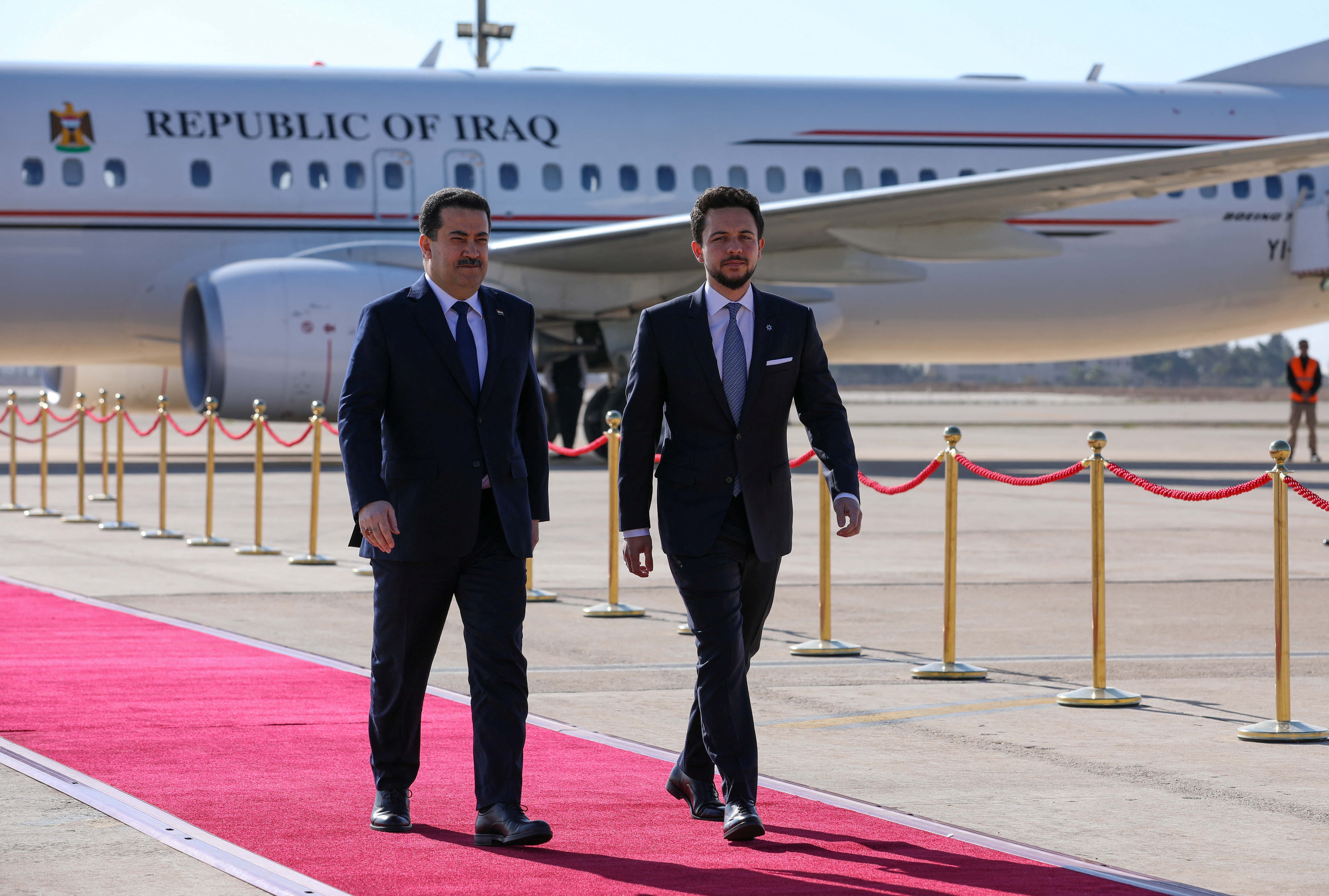 Jordan's Crown Prince Al Hussein walks with Iraqi Prime Minister Mohammed Shia al-Sudani upon his arrival at Queen Alia International Airport in Amman