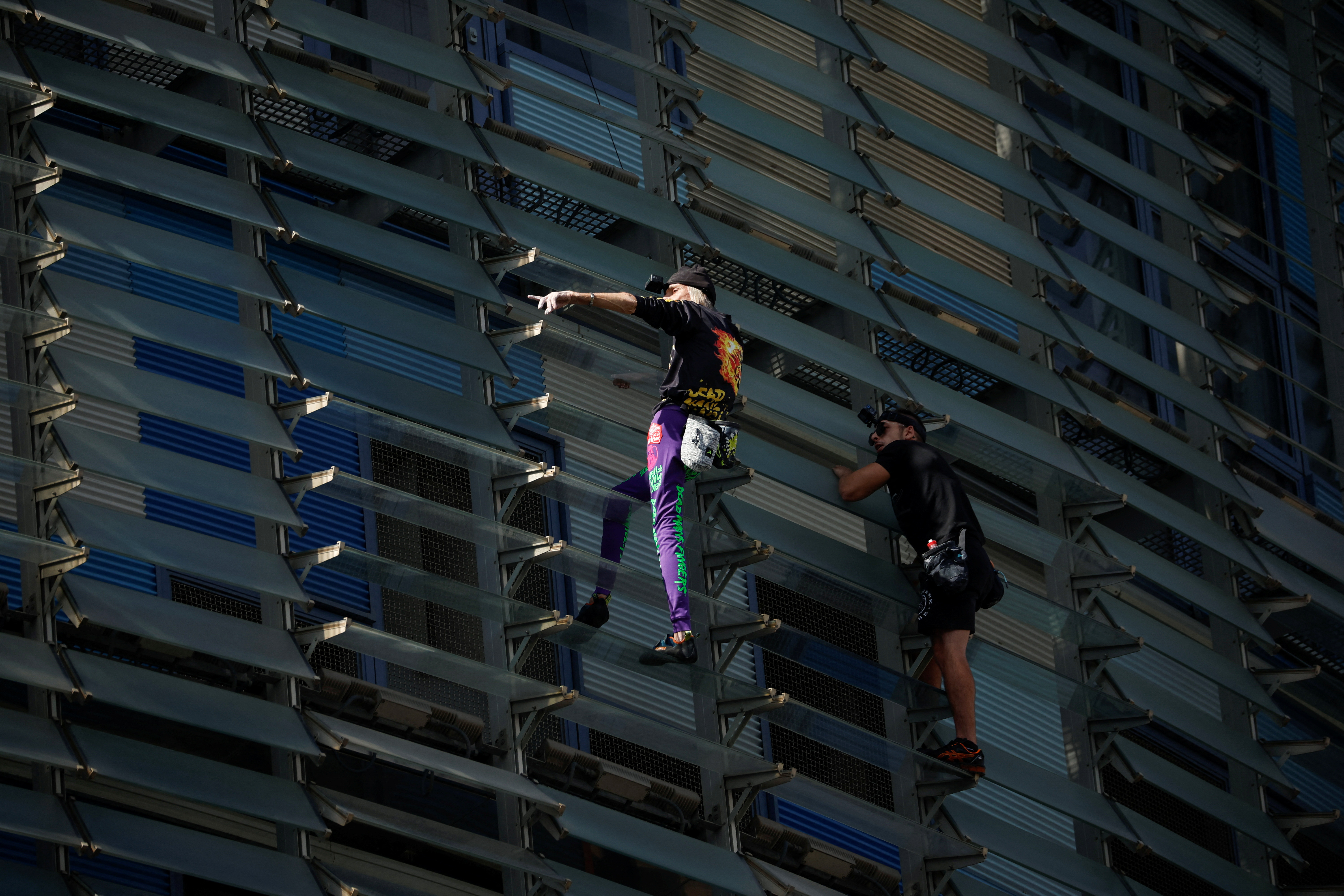 French Spiderman' climbs first skyscraper with son in Barcelona | Reuters