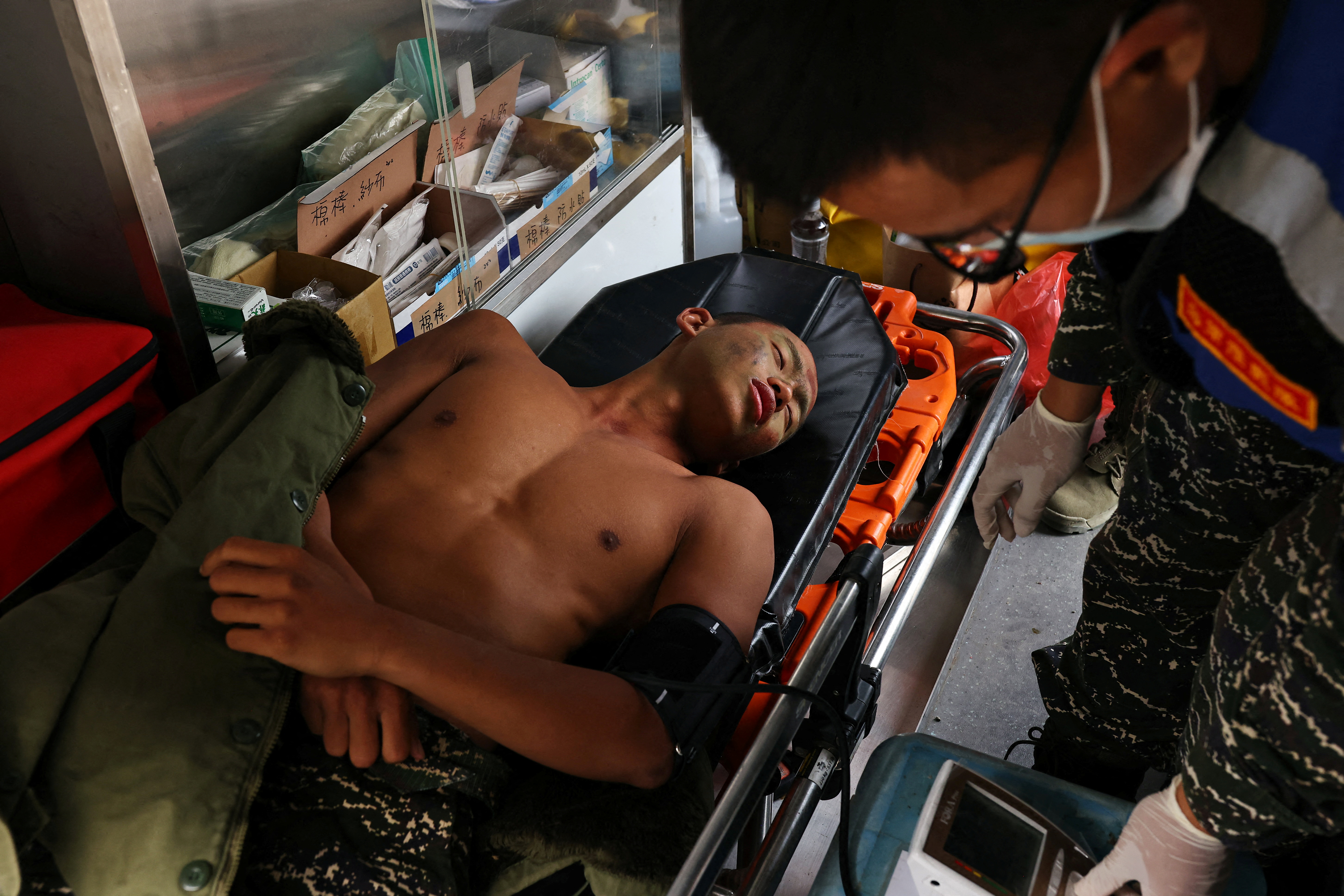 Liu Zi-Xian, 25, has his blood pressure measured in an ambulance after falling ill during the last week of a ten week program to become a member of the Taiwan navy's elite Amphibious Reconnaissance and Patrol unit, at Zuoying navy base, Kaohsiung, southern Taiwan, December 19, 2021. The trainees have to endure everything from long marches to hours in the water, with constant screaming at by their instructors. Of the group of 31 who started the program, only 15 finished.   REUTERS/Ann Wang      