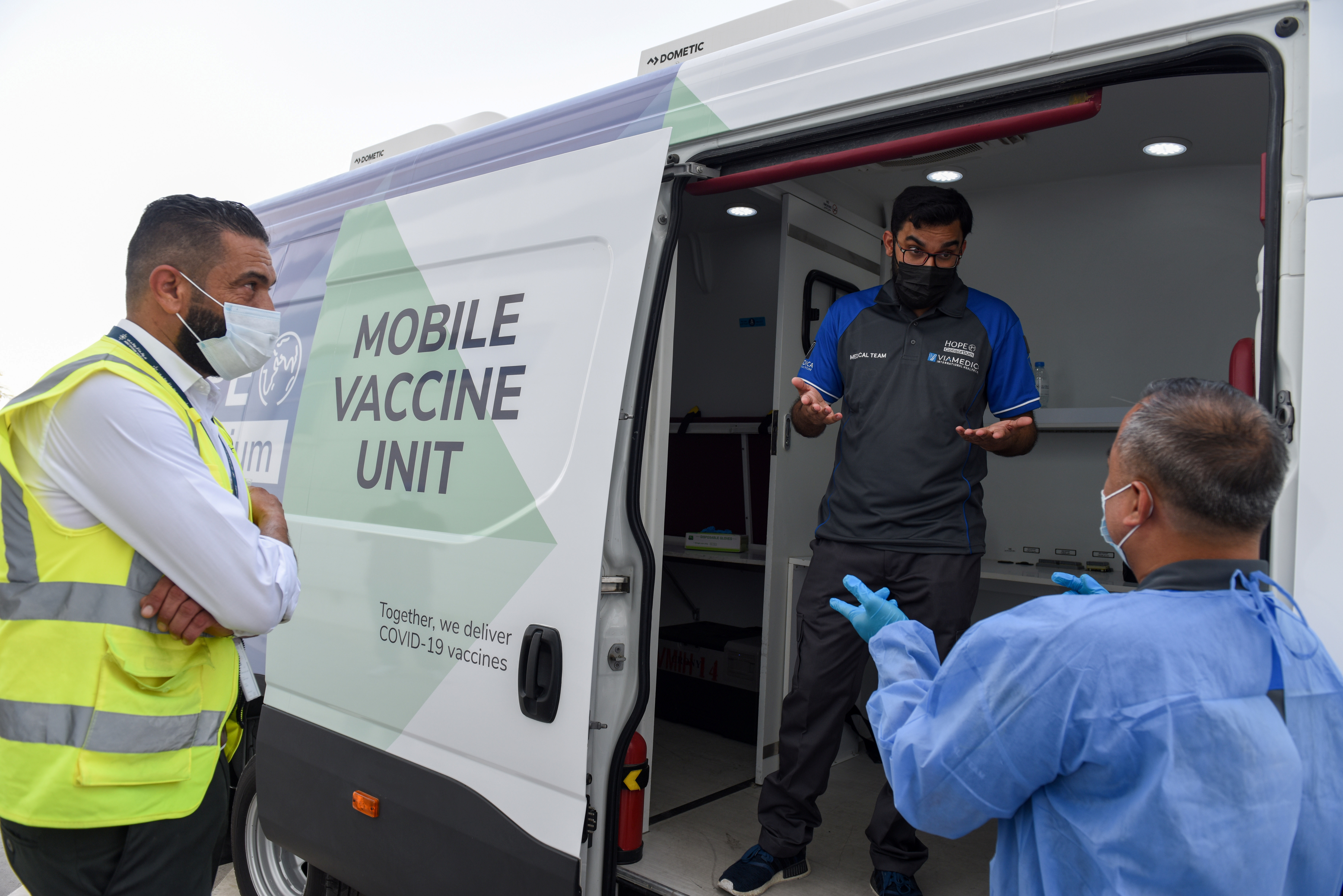 People talk at a mobile vaccine unit of Abu Dhabi based Hope Consortium which partnered with Via Medical International Healthcare to the deliver the service at Abu Dhabi