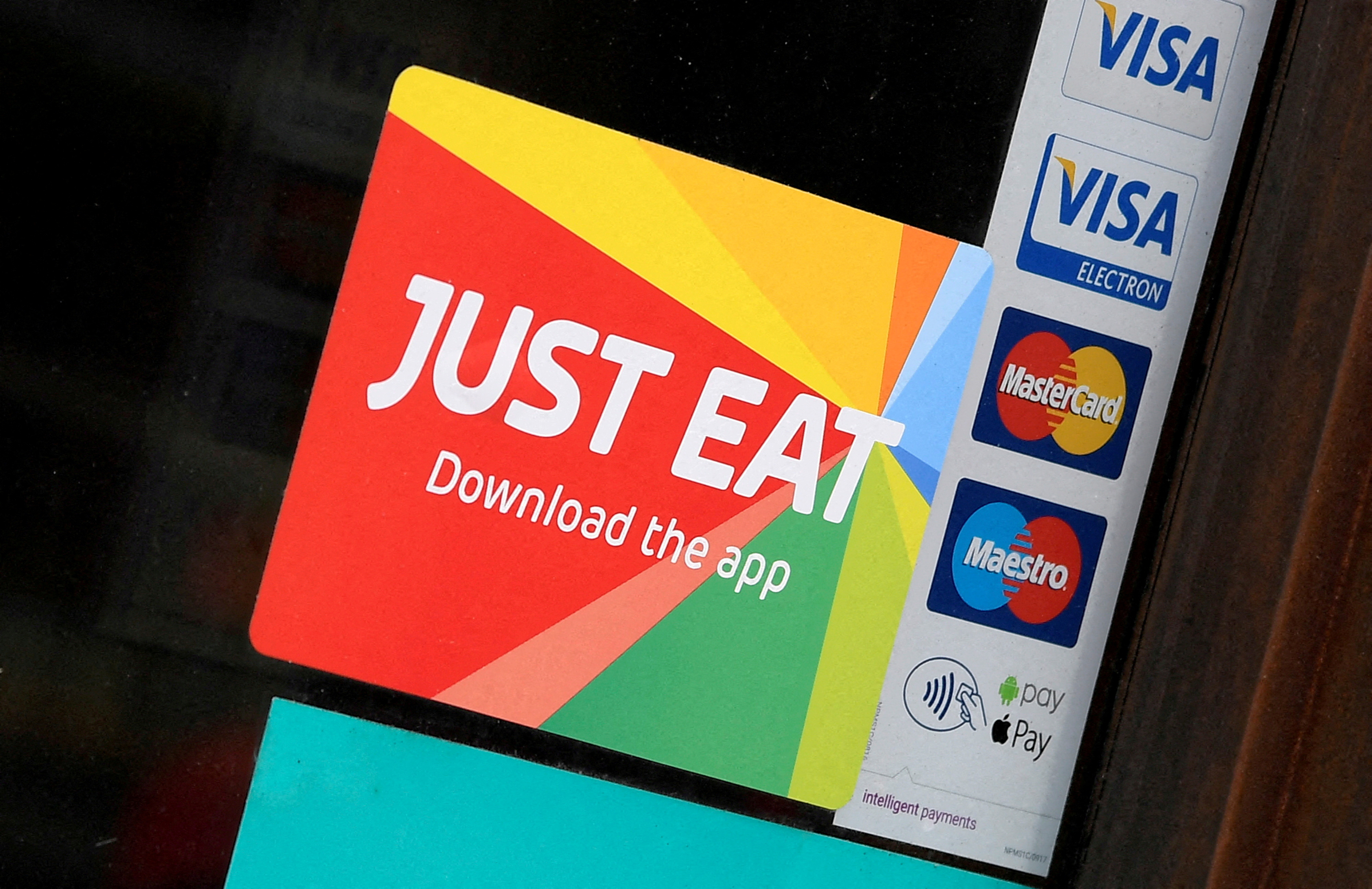Signage for Just Eat is seen on the window of a restaurant in London