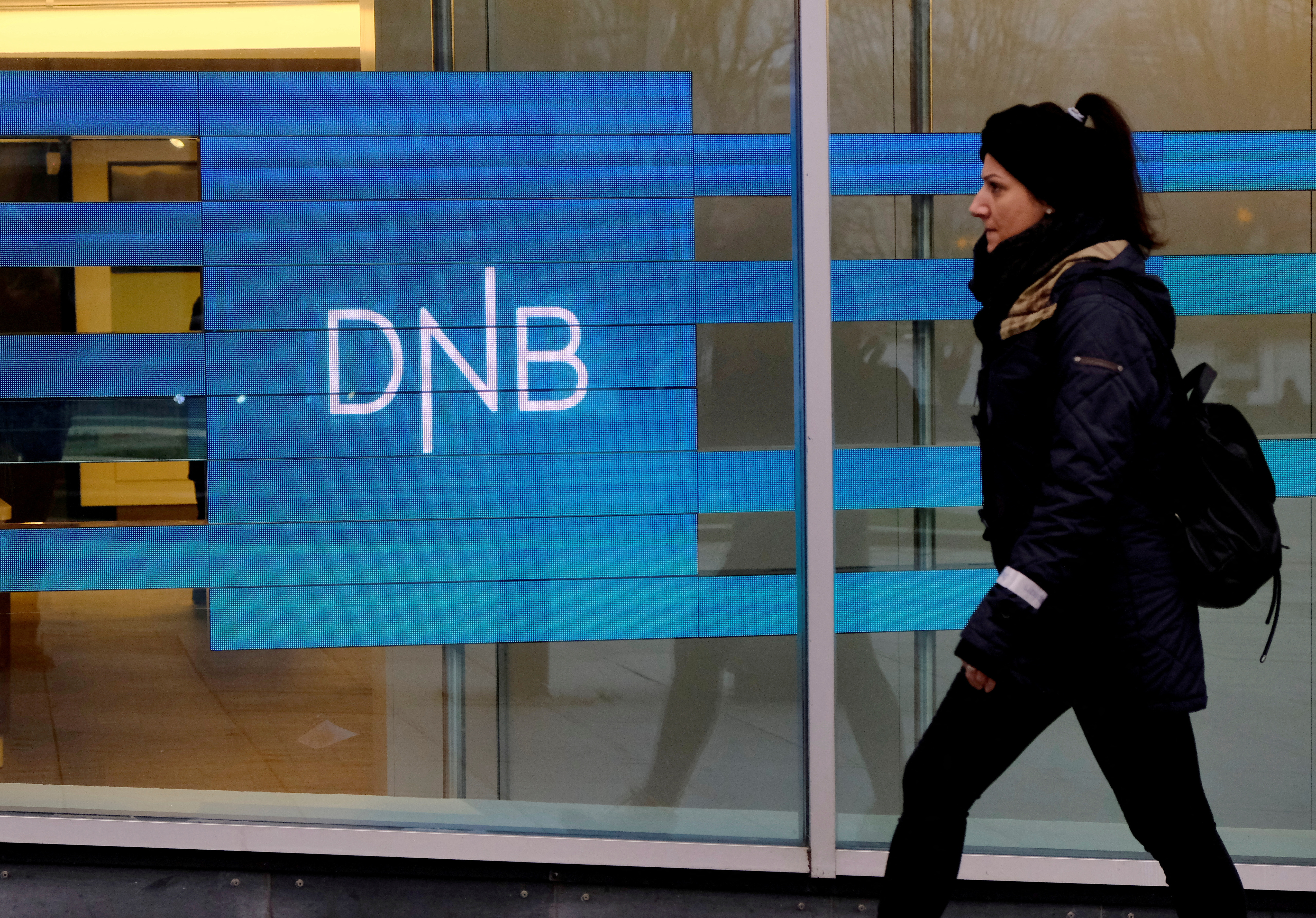 A woman walks past DNB bank branch in Stavanger