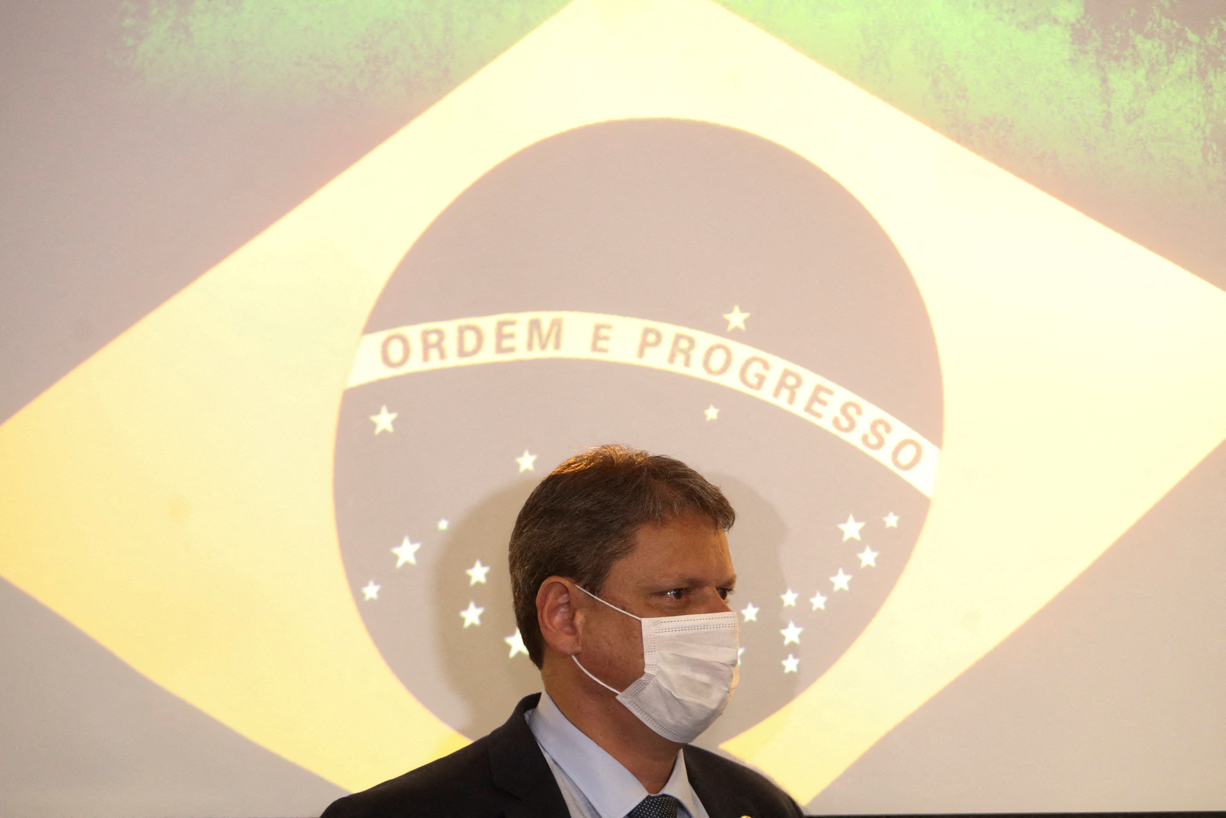 Brazil's Minister of Infrastructure Tarcisio Gomes de Freitas walks past a projection of the Brazilian flag during a press conference at Federation of Industries of the State of Sao Paulo (FIESP) in Sao Paulo