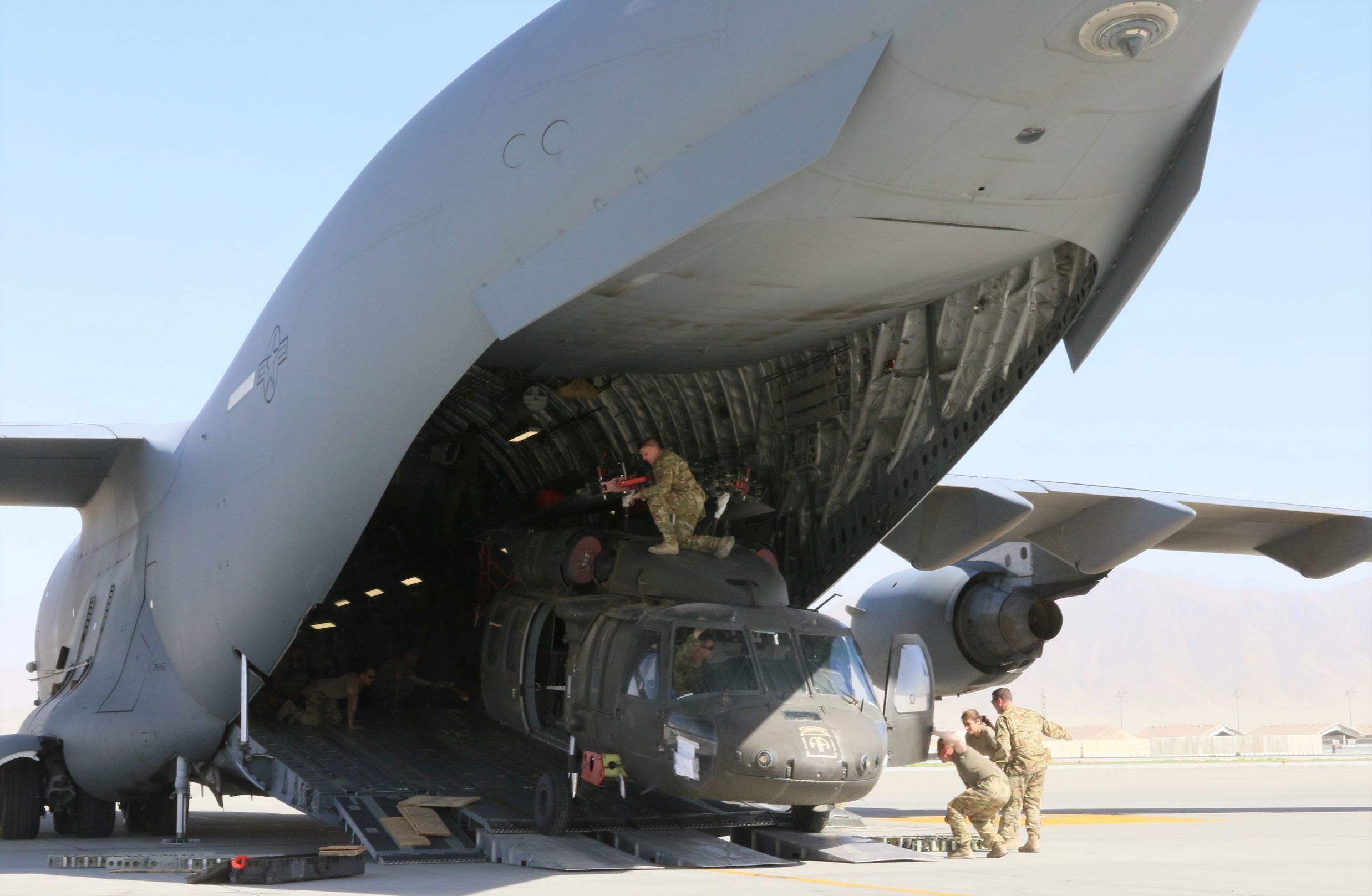 Aerial porters work with maintainers to load a UH-60L Blackhawk helicopter into a U.S. Air Force C-17 Globemaster III during the withdrawl of American forces in Afghanistan, June 16, 2021. Picture taken June 16, 2021. U.S. Army/Sgt. 1st Class Corey Vandiver/Handout via REUTERS