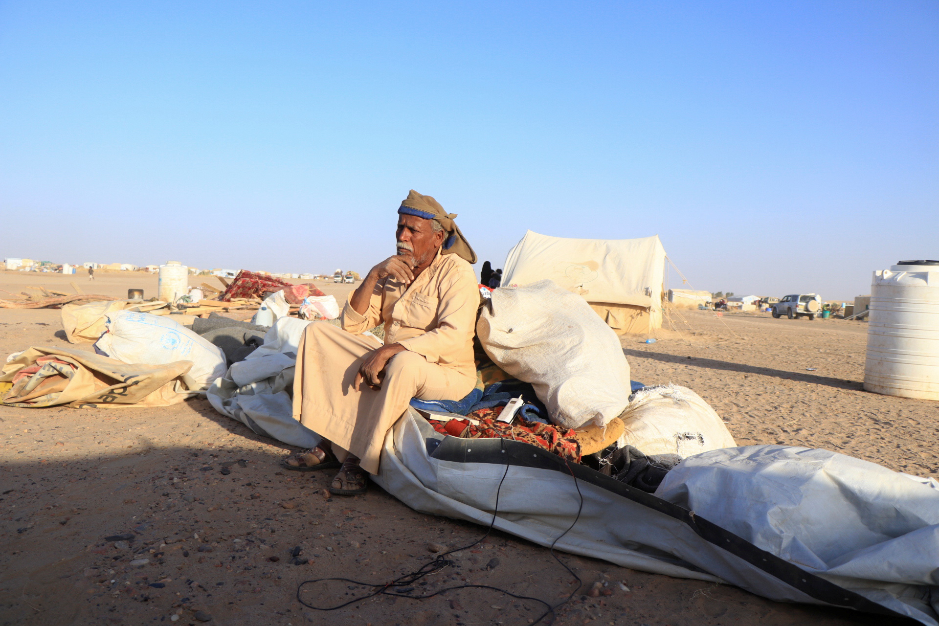 A man sits on belongings after arriving in a camp for internally displaced people (IDPs) in Marib, Yemen