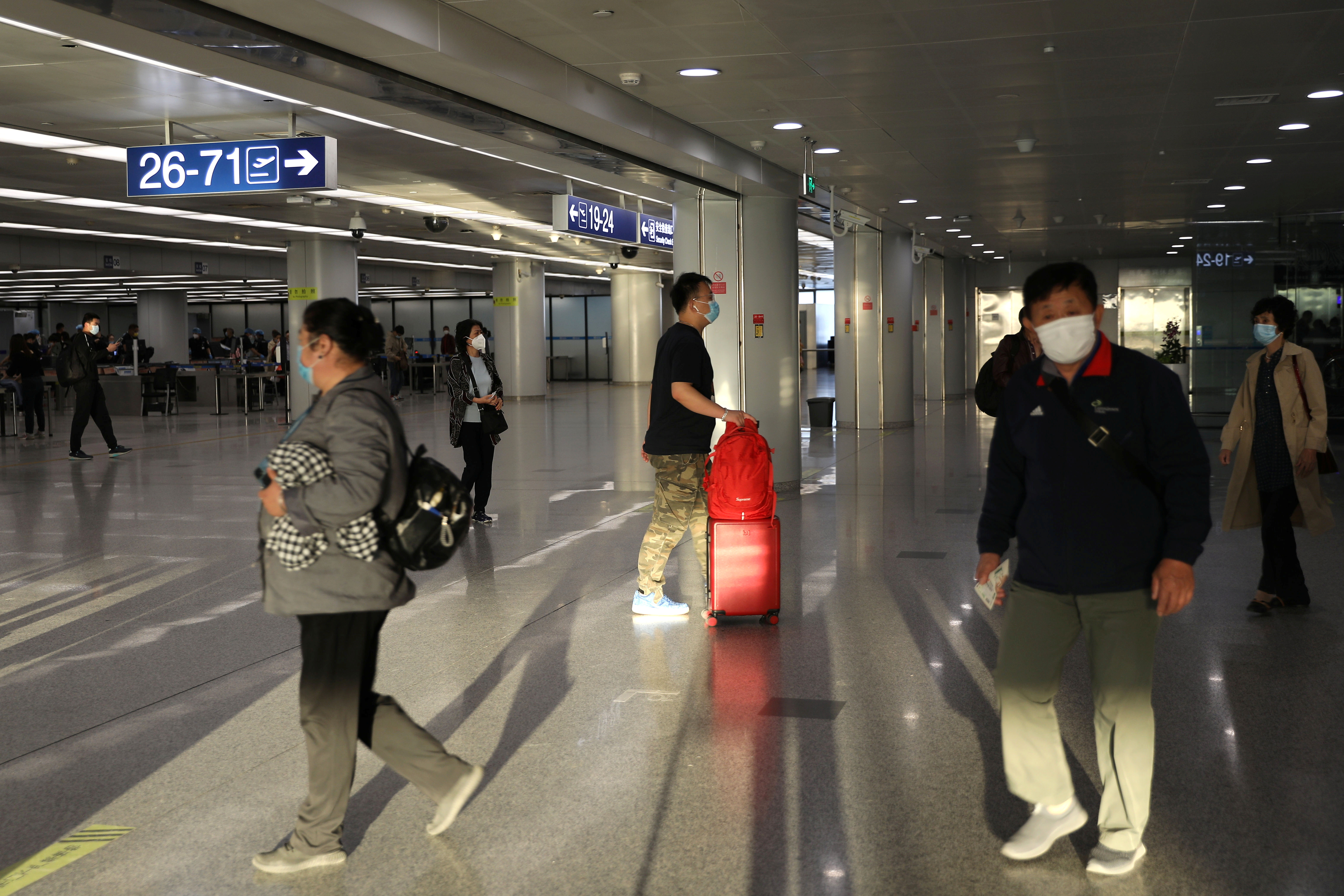 Travellers walk at the Beijing Capital International Airport in Beijing