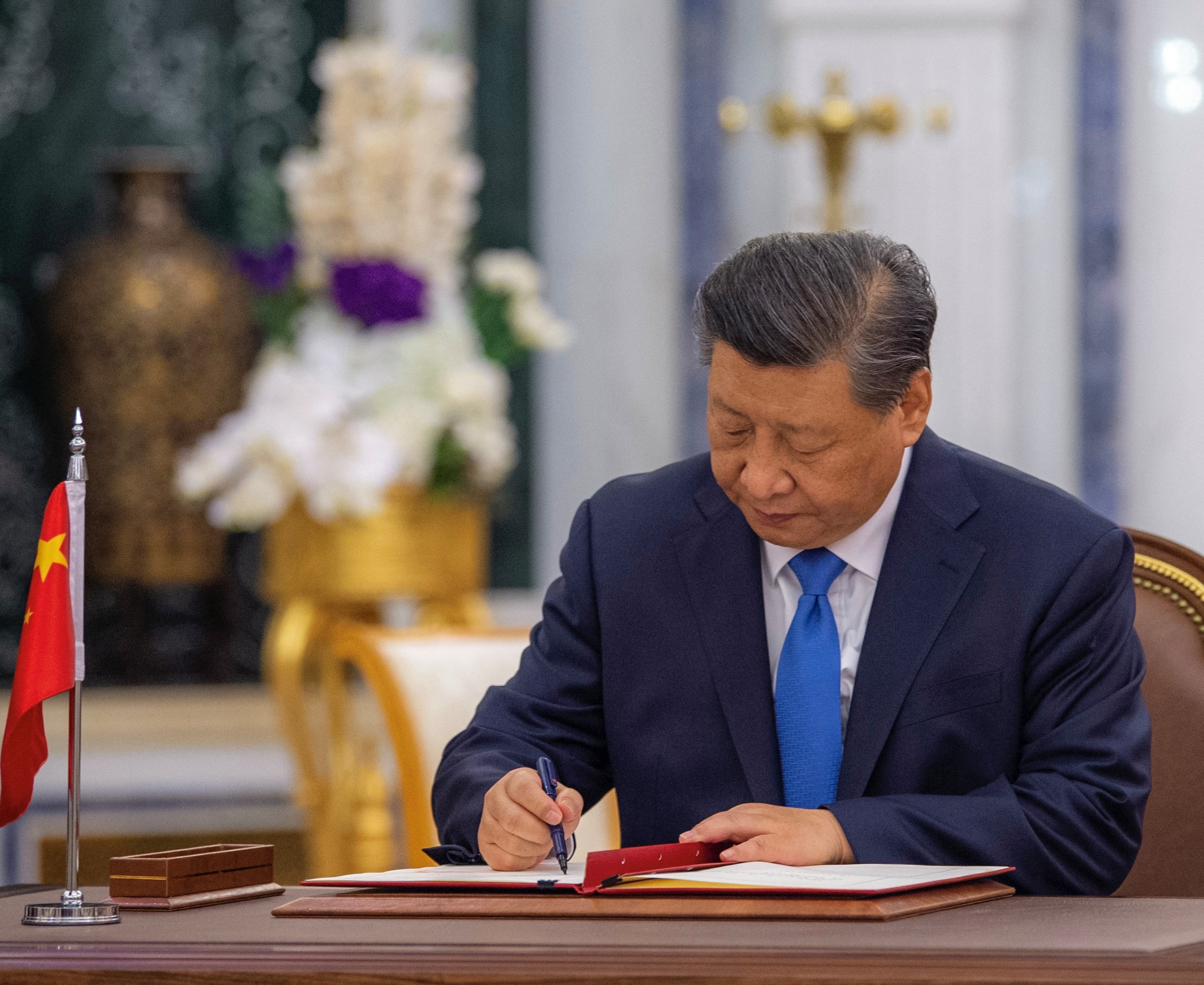 Chinese President Xi signs a document during meeting with Saudi king in Riyadh