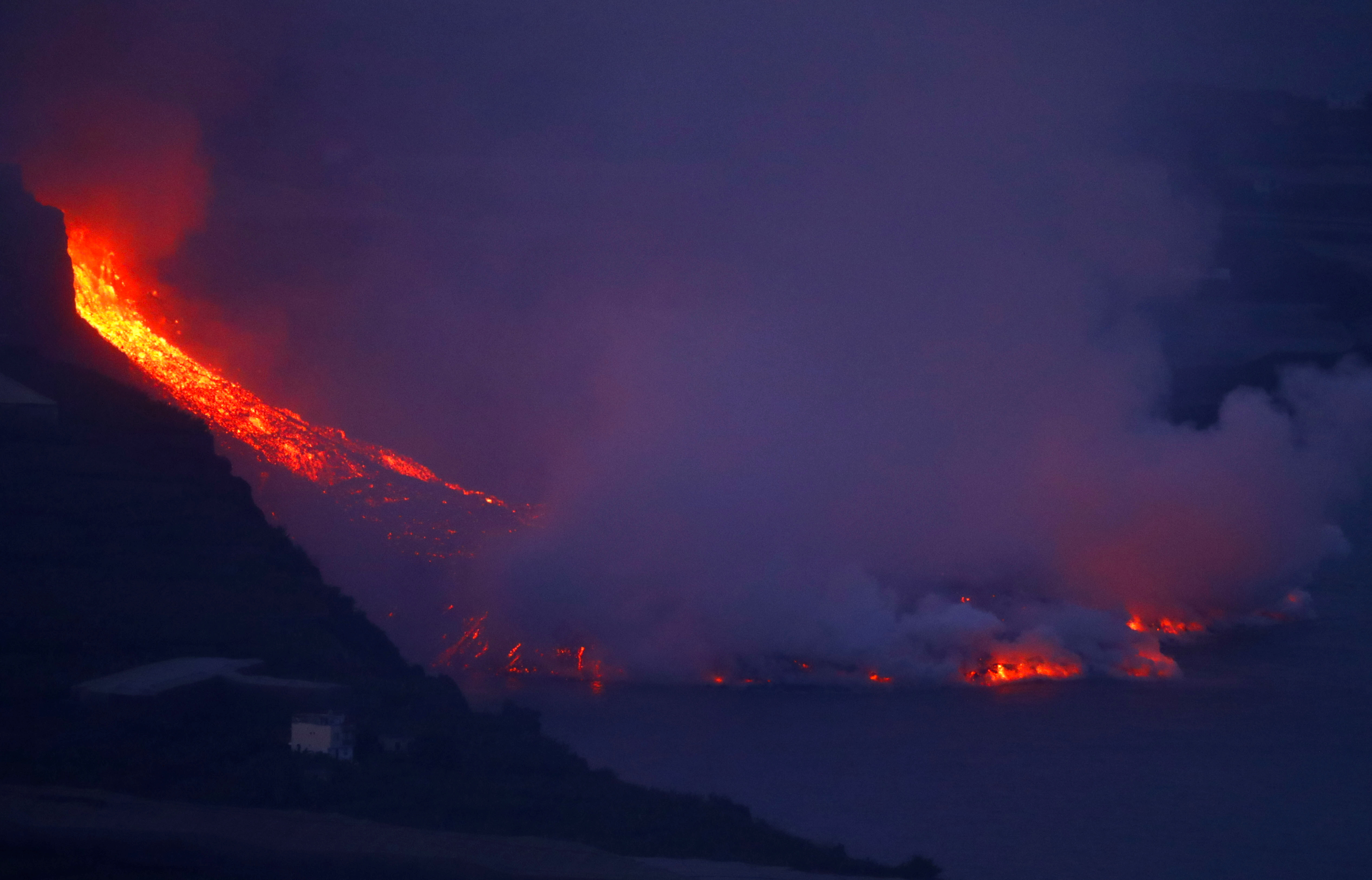 Lava flows into the sea, as seen from Tijarafe, following the eruption of a volcano on the Canary Island of La Palma, Spain, September 29, 2021. REUTERS/Borja Suarez