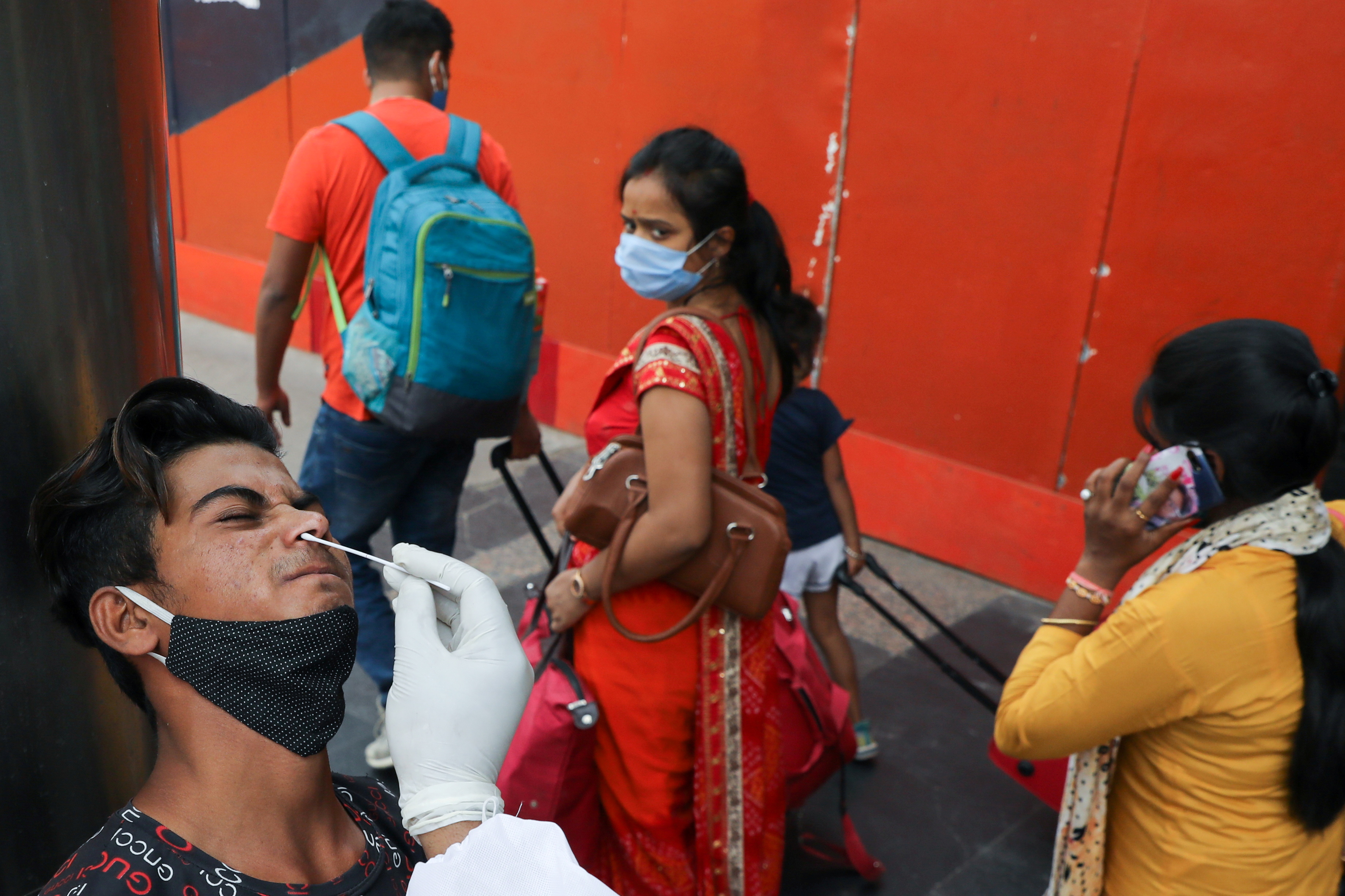 A man reacts as a healthcare worker collects a swab sample, amidst the spread of the coronavirus disease (COVID-19), at a railway station, in New Delhi, India, April 7, 2021. REUTERS/Anushree Fadnavis    