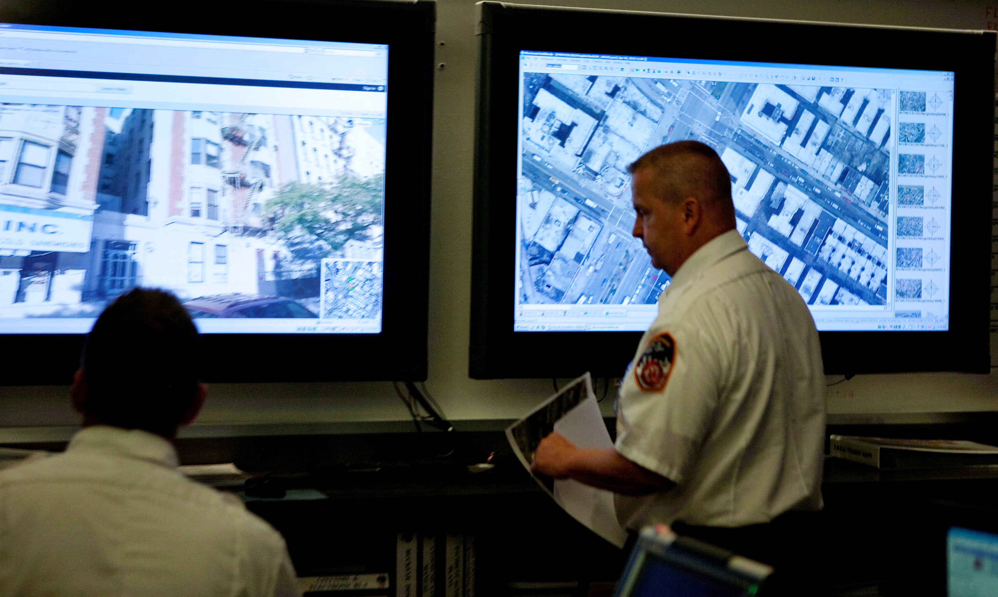 Officers from the New York Fire Department look at aerial and street imagery of a building in New York