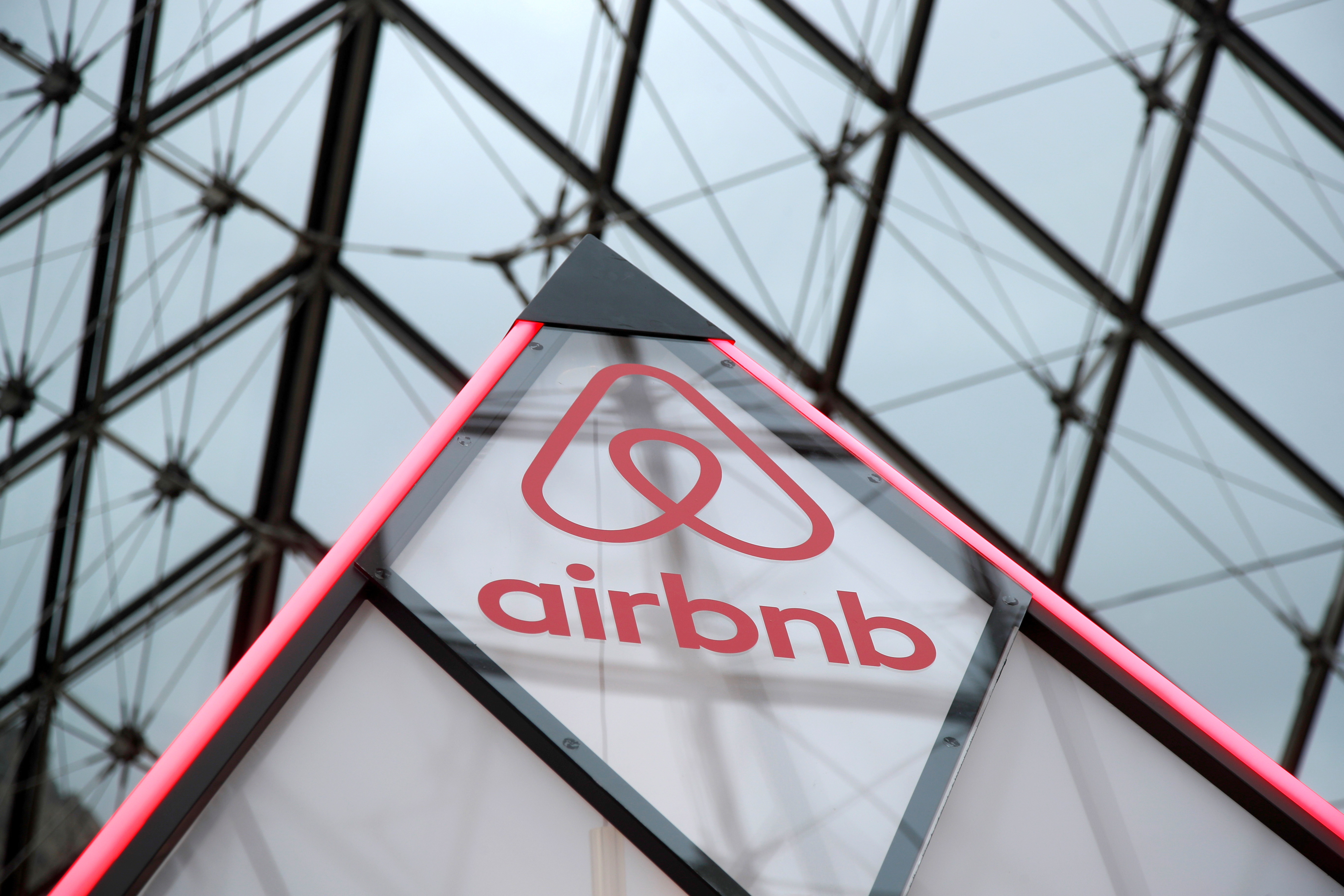 Airbnb logo is seen on a little mini pyramid under the glass Pyramid of the Louvre museum in Paris
