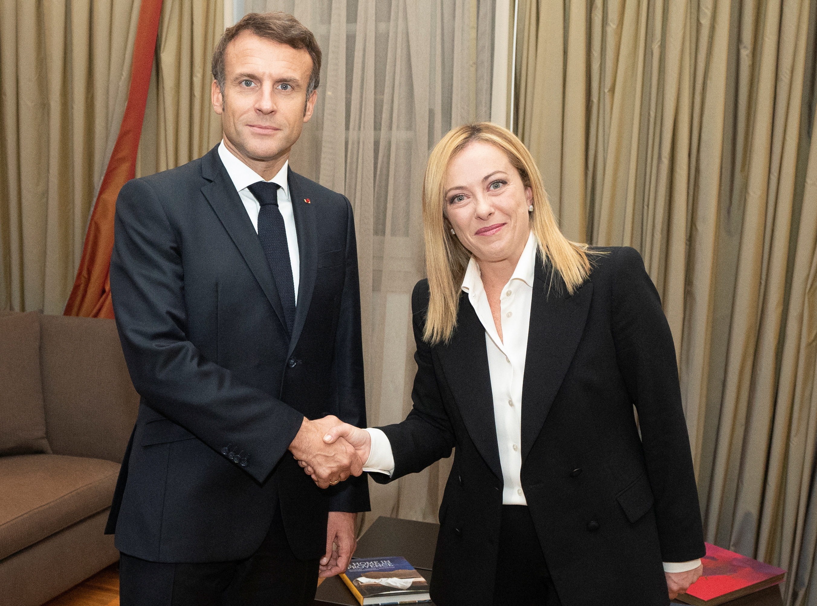 Italian Prime Minister Giorgia Meloni shakes hands with French President Emmanuel Macron during a meeting in Rome