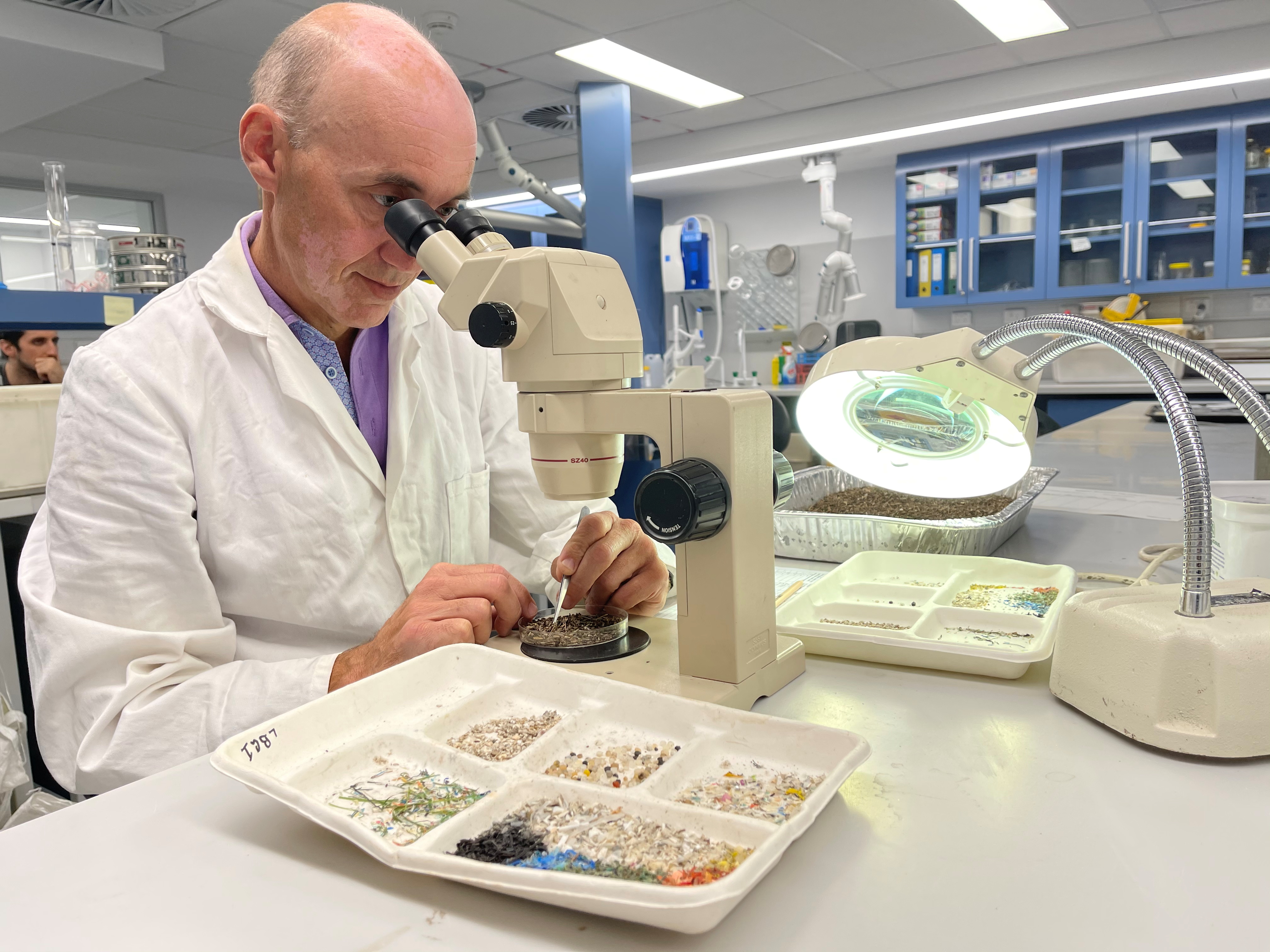 Australian Microplastic Assessment Project Research Director Dr Scott Wilson looks at microplastics through a microscope at Macquarie University in Sydney