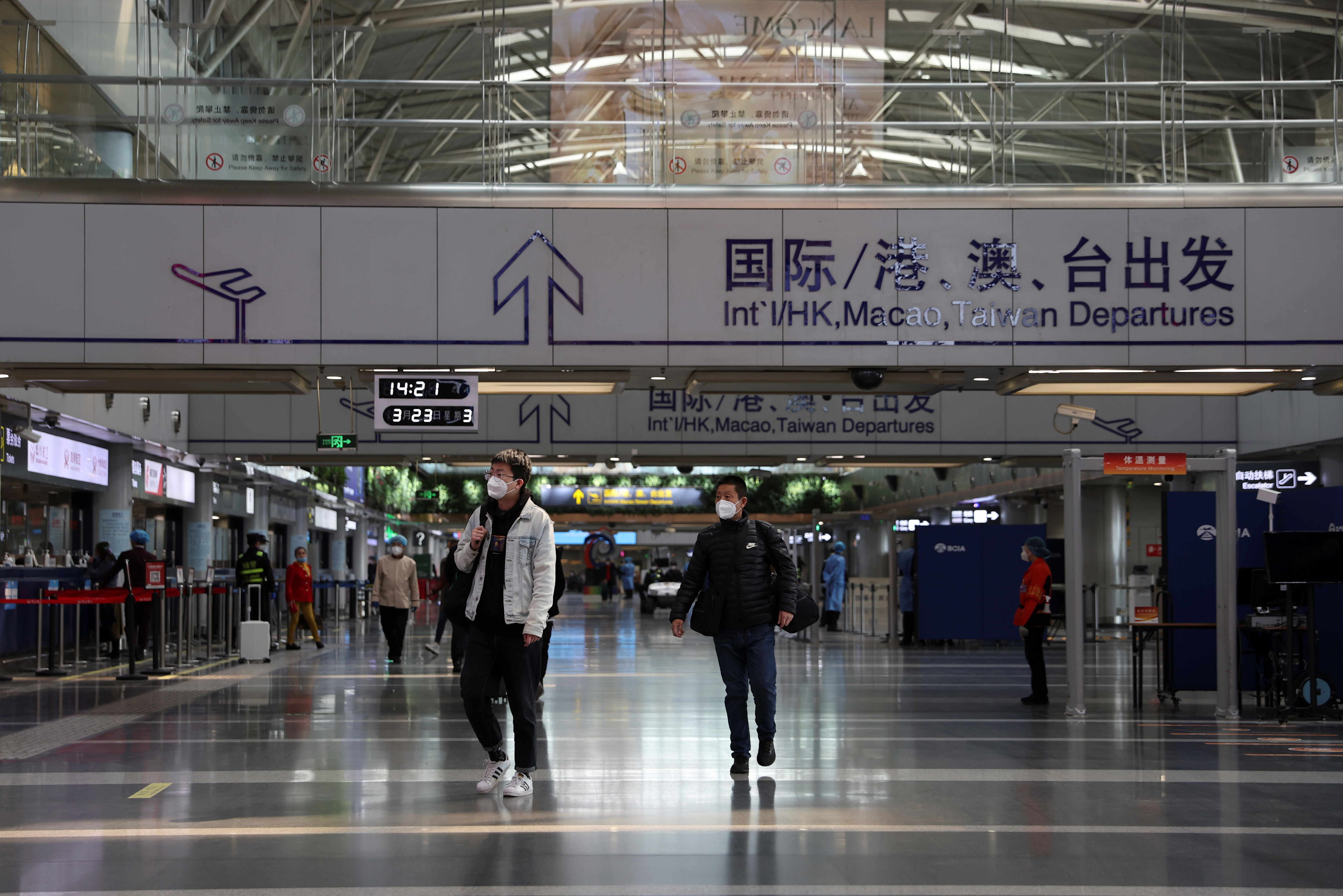 Travellers walk at a terminal hall of the Beijing Capital International Airport