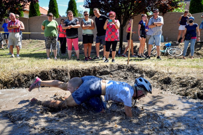 Participants compete in a wife-carrying championship in Tapiobicske, Hungary, August 7, 2021. REUTERS/Marton Monus