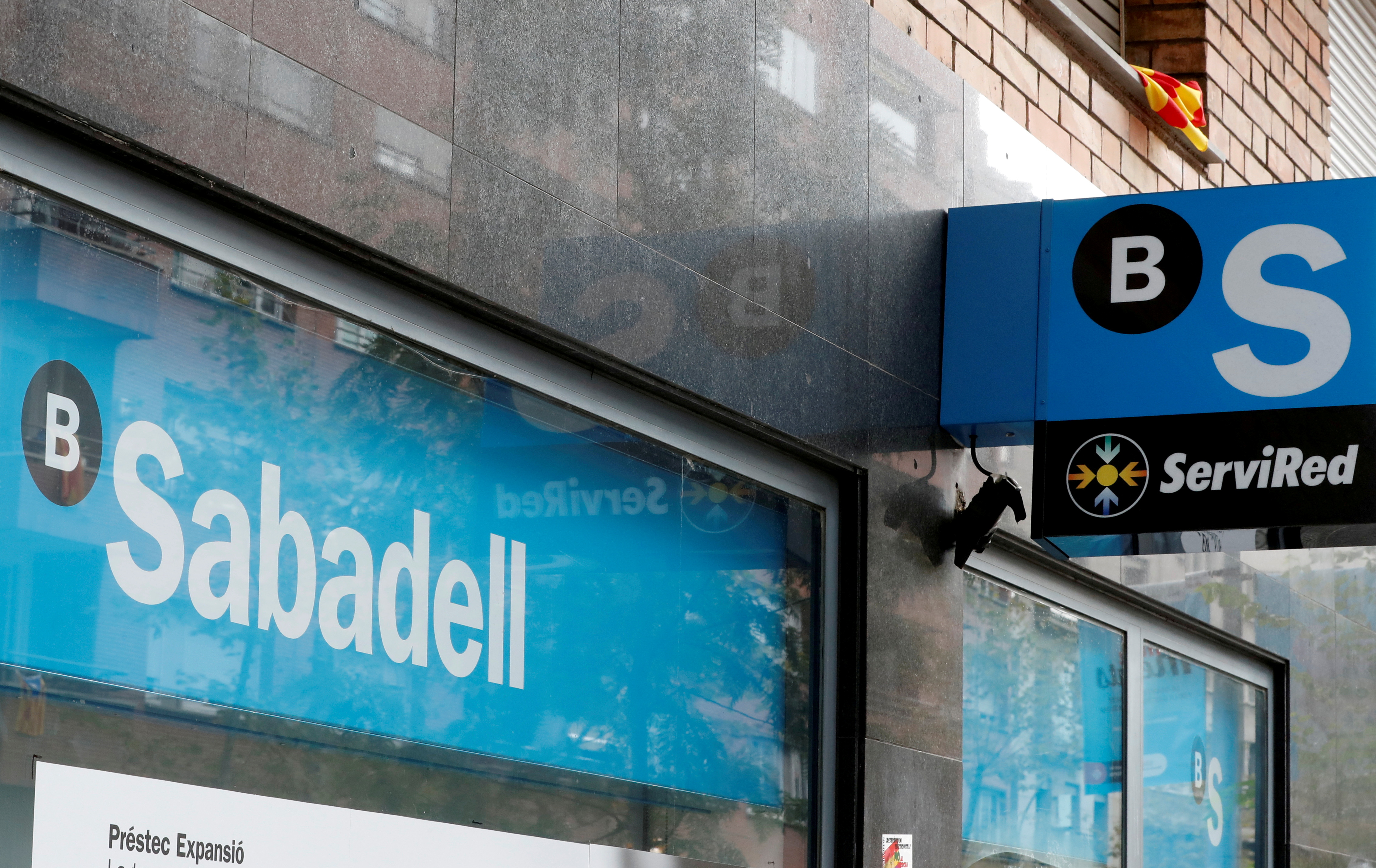 A Catalan flag is seen above a logo at the Sabadell bank branch in Barcelona