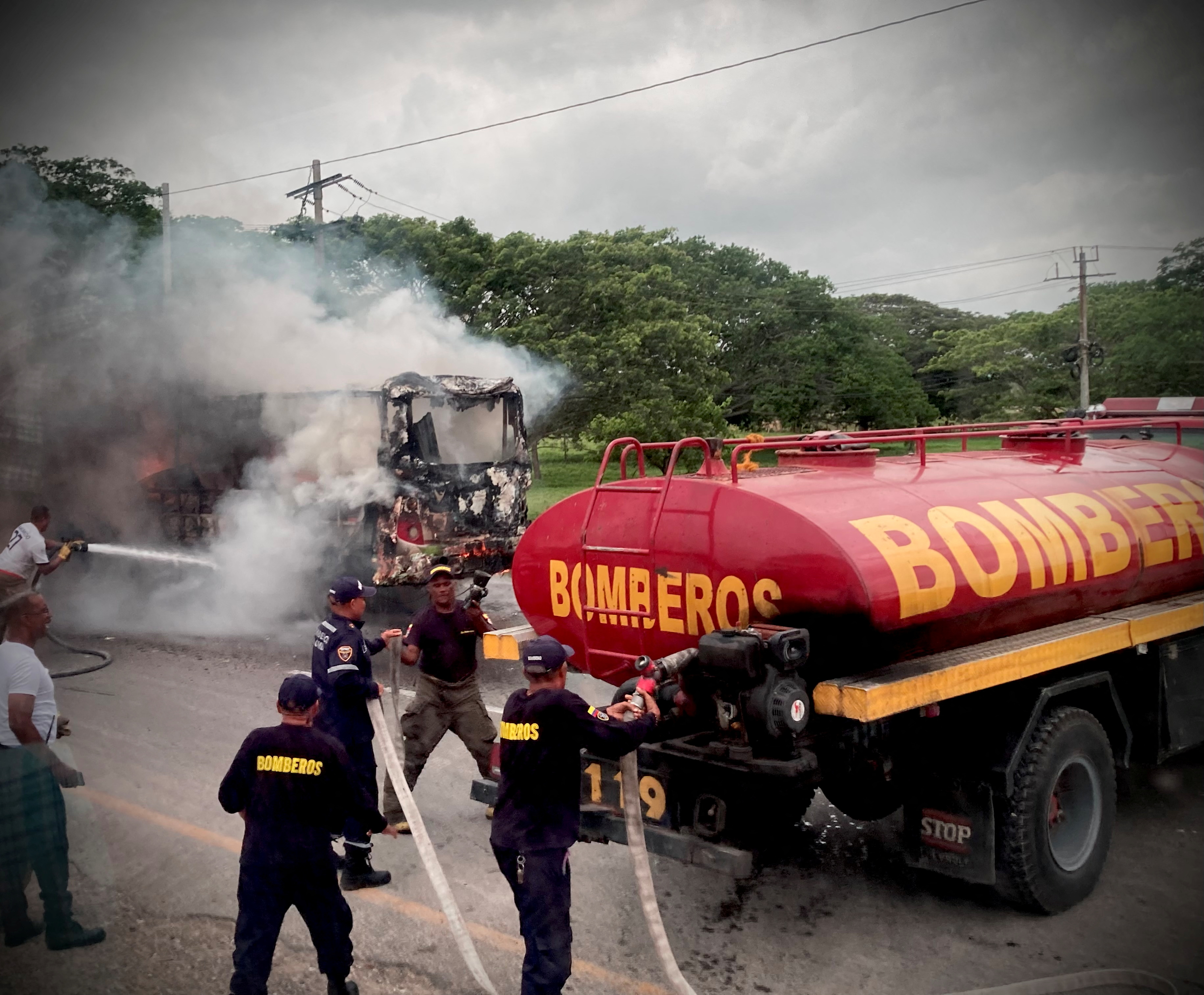 Colombian firefighters tend to a burning vehicle in Bolivar