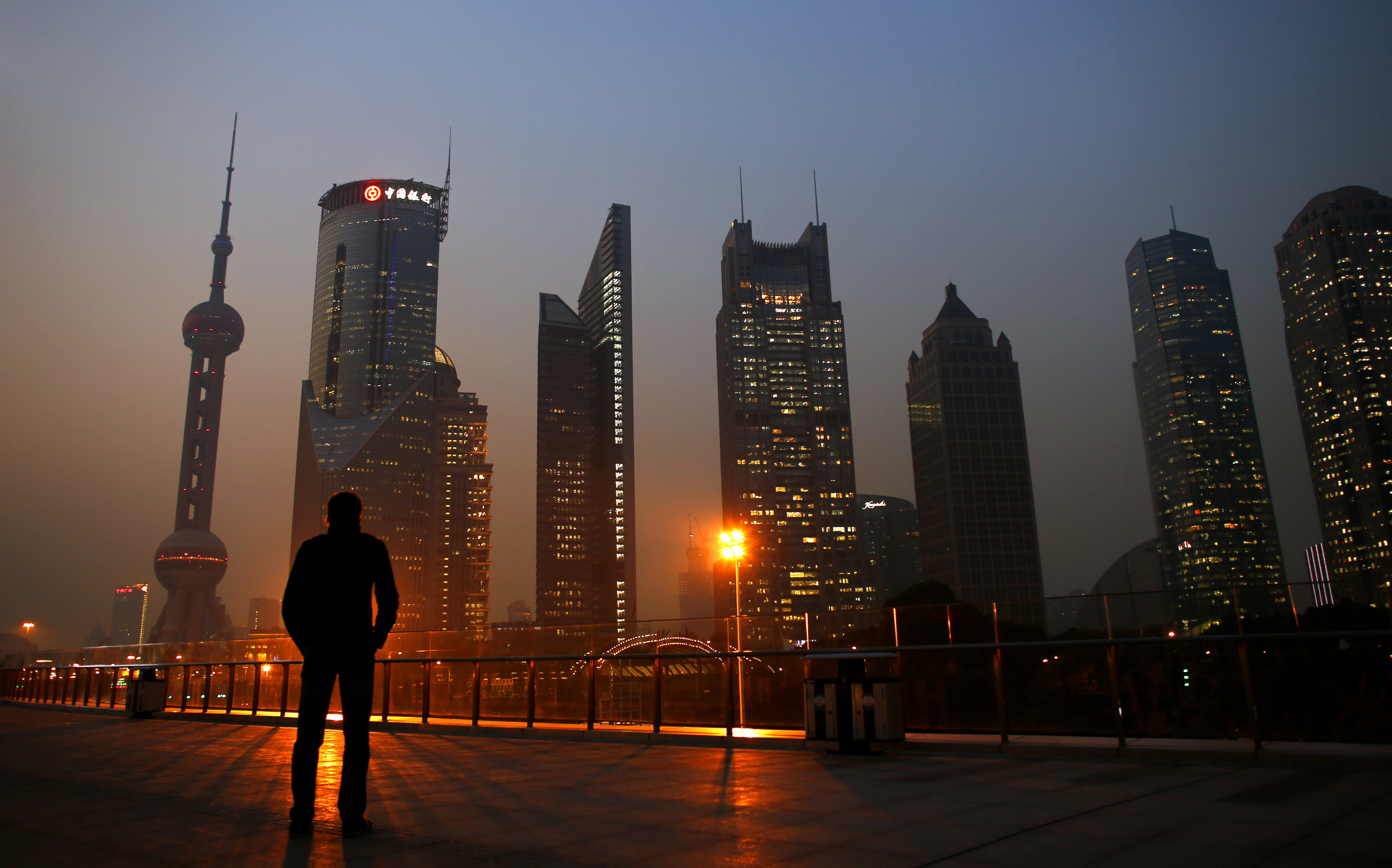 Man looks at the Pudong financial district of Shanghai