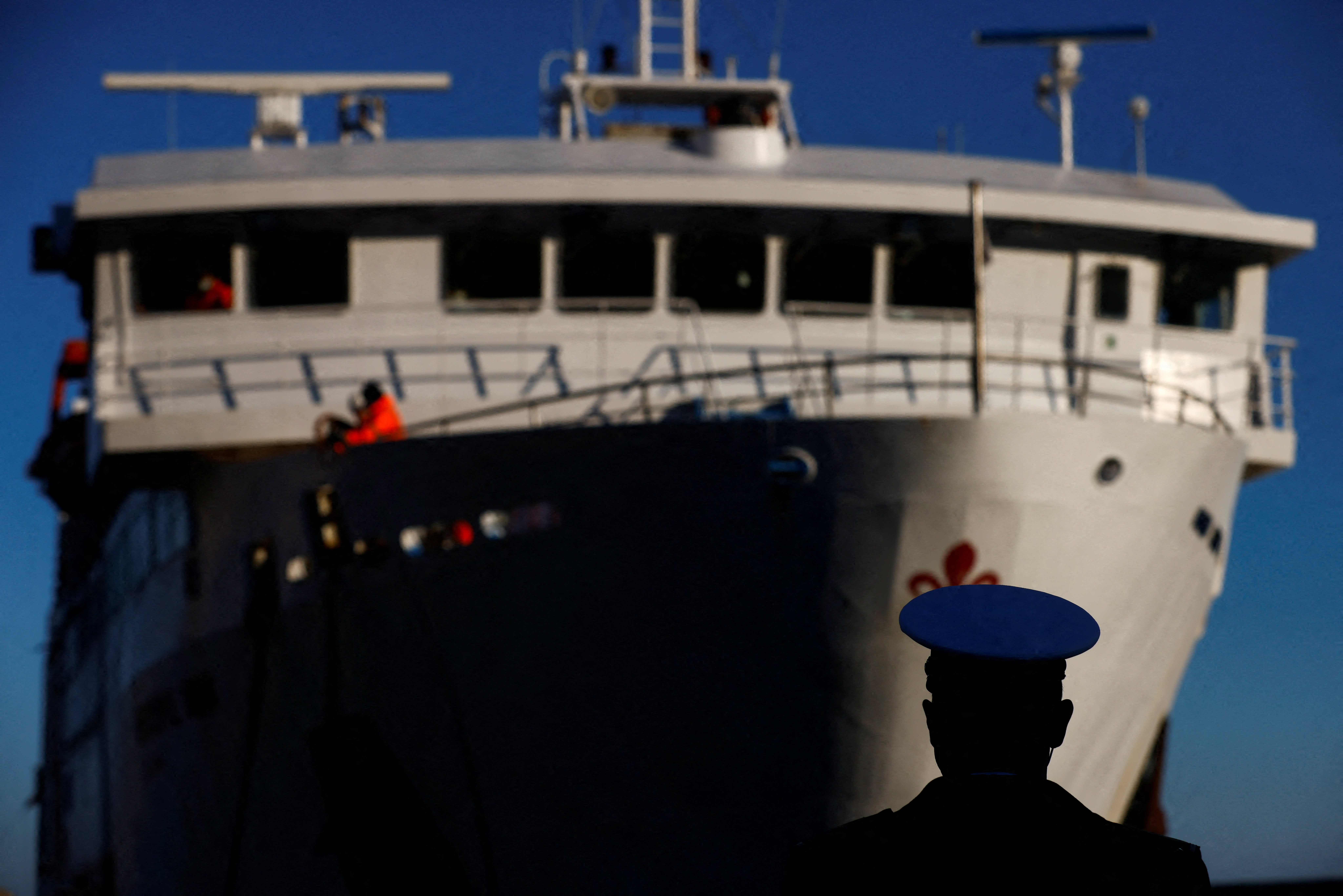 Član lučkih uprava gleda kako trajekt stiže na dan desete godišnjice brodoloma Costa Concordia u kojem su poginule 32 osobe nakon što se prevrnuo i potonuo s obale, na otoku Giglio, Italija, 13. siječnja 2022. REUTERS/Yara Nardi