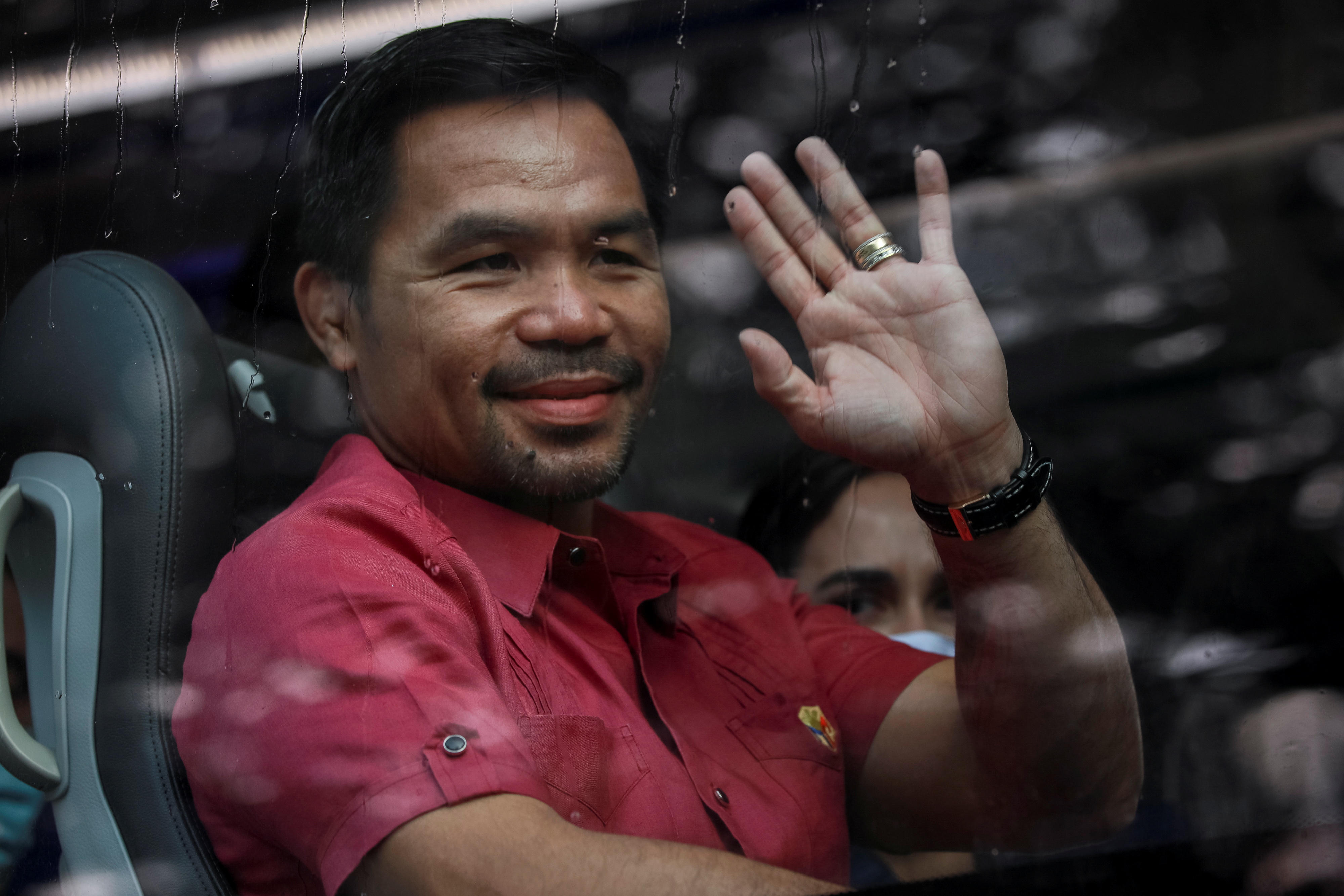 Philippine senator and newly retired boxing icon Manny Pacquiao waves from his bus before filing his certificate of candidacy for president, in Pasay City, Metro Manila, Philippines, October 1, 2021. REUTERS/Eloisa Lopez