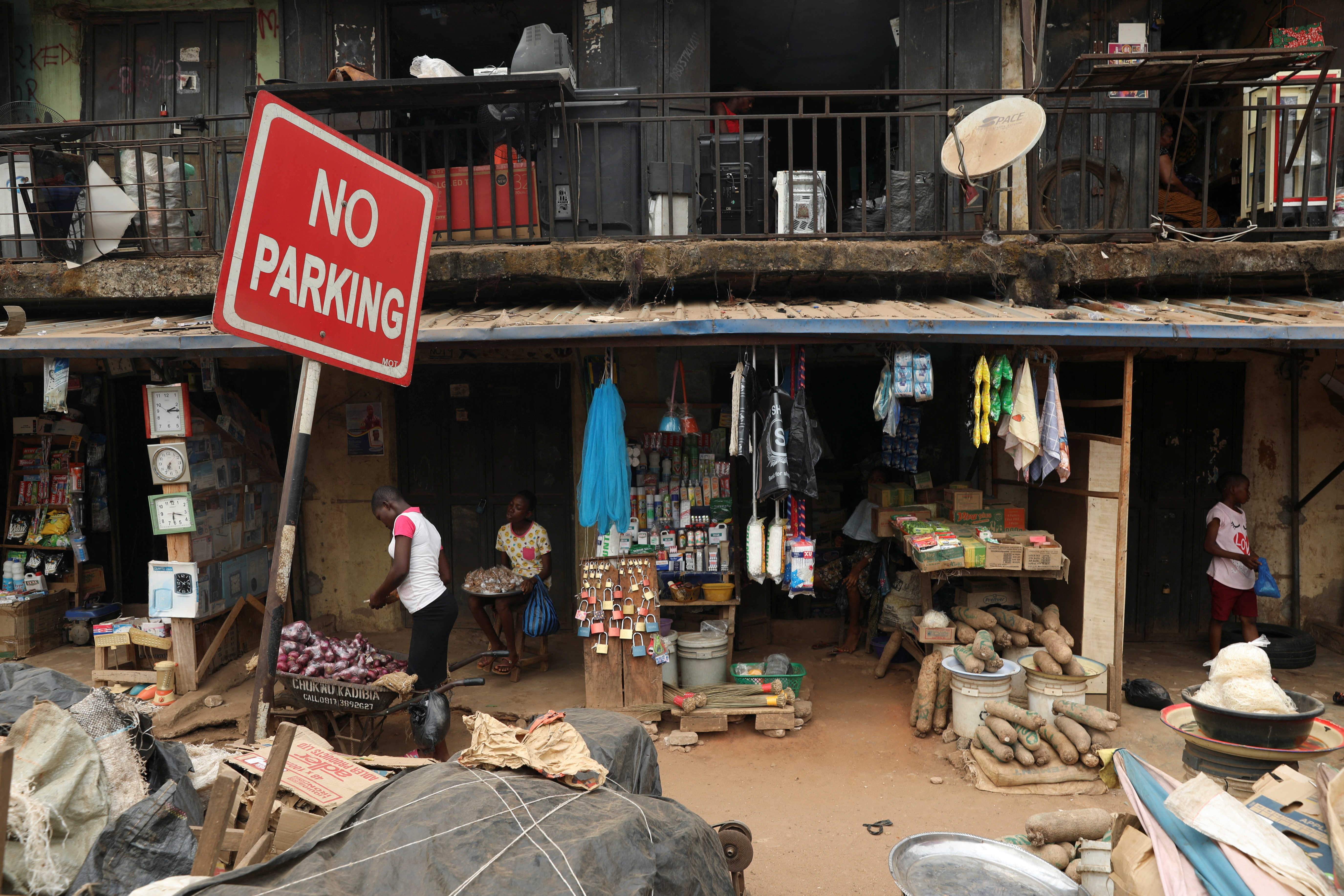 A No Parking road sign is seen in front of a shopping complex in an open market, ahead of Nigeria's Presidential election in Awka