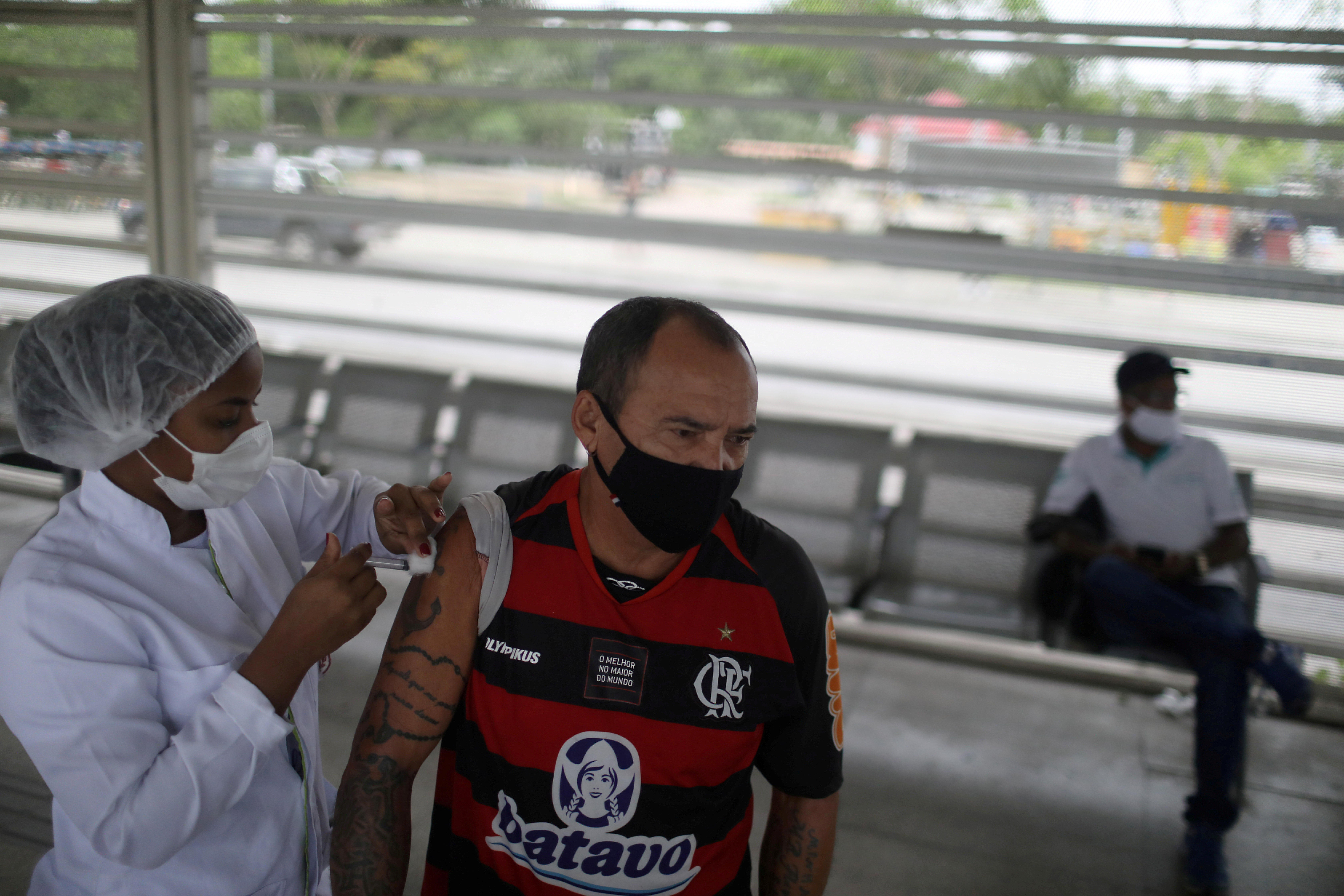 A man receives a dose of the Pfizer-BioNTech coronavirus disease (COVID-19) vaccine at the Bus Rapid Transit (BRT) station in Rio de Janeiro, Brazil October 27, 2021. REUTERS/Pilar Olivares/File Photo