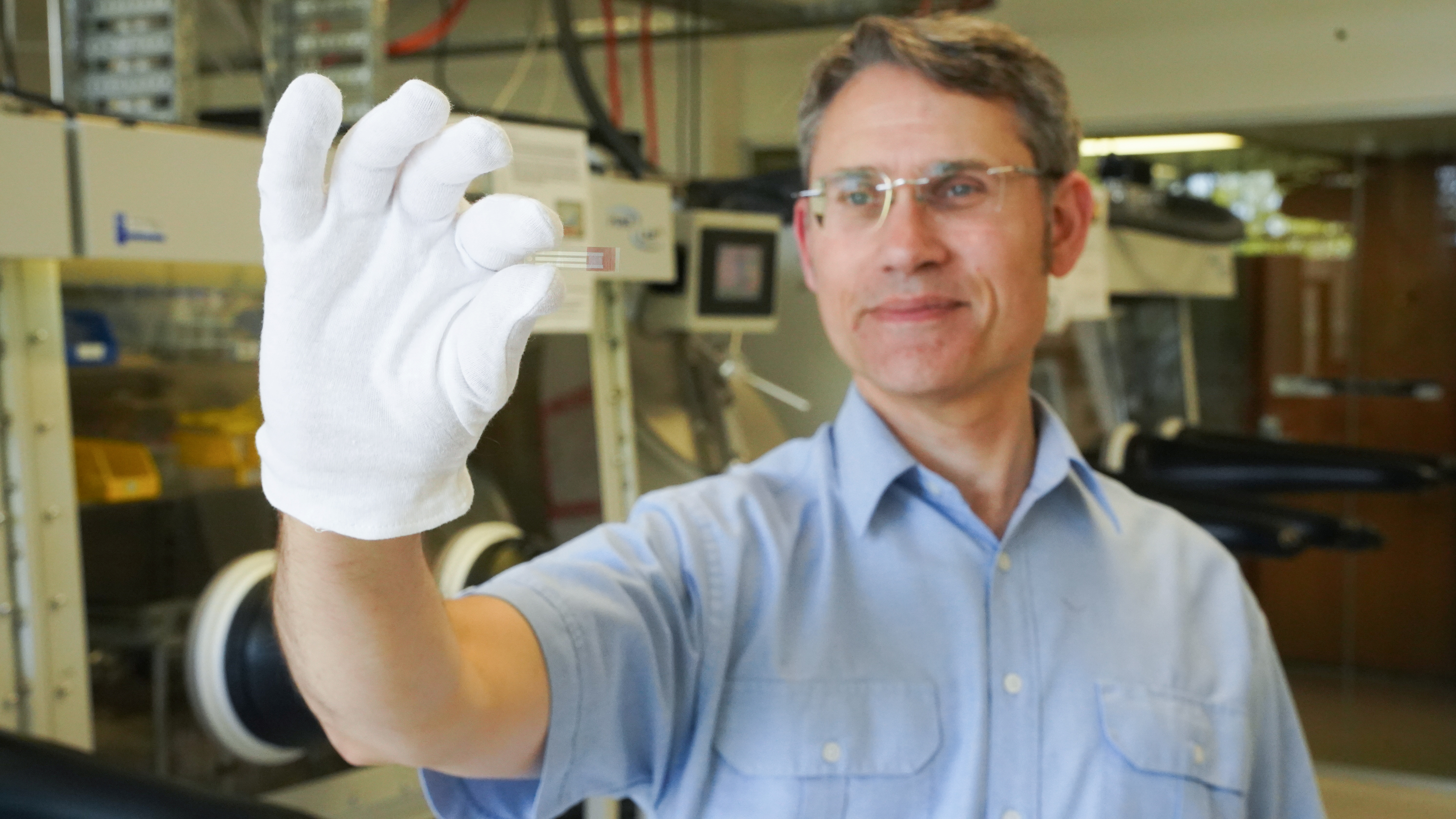 Paul Dastoor, Physicist and Research Leader at the University of Newcastle, holds a non-invasive, printable saliva test strip for diabetics, at the University of Newcastle in Australia