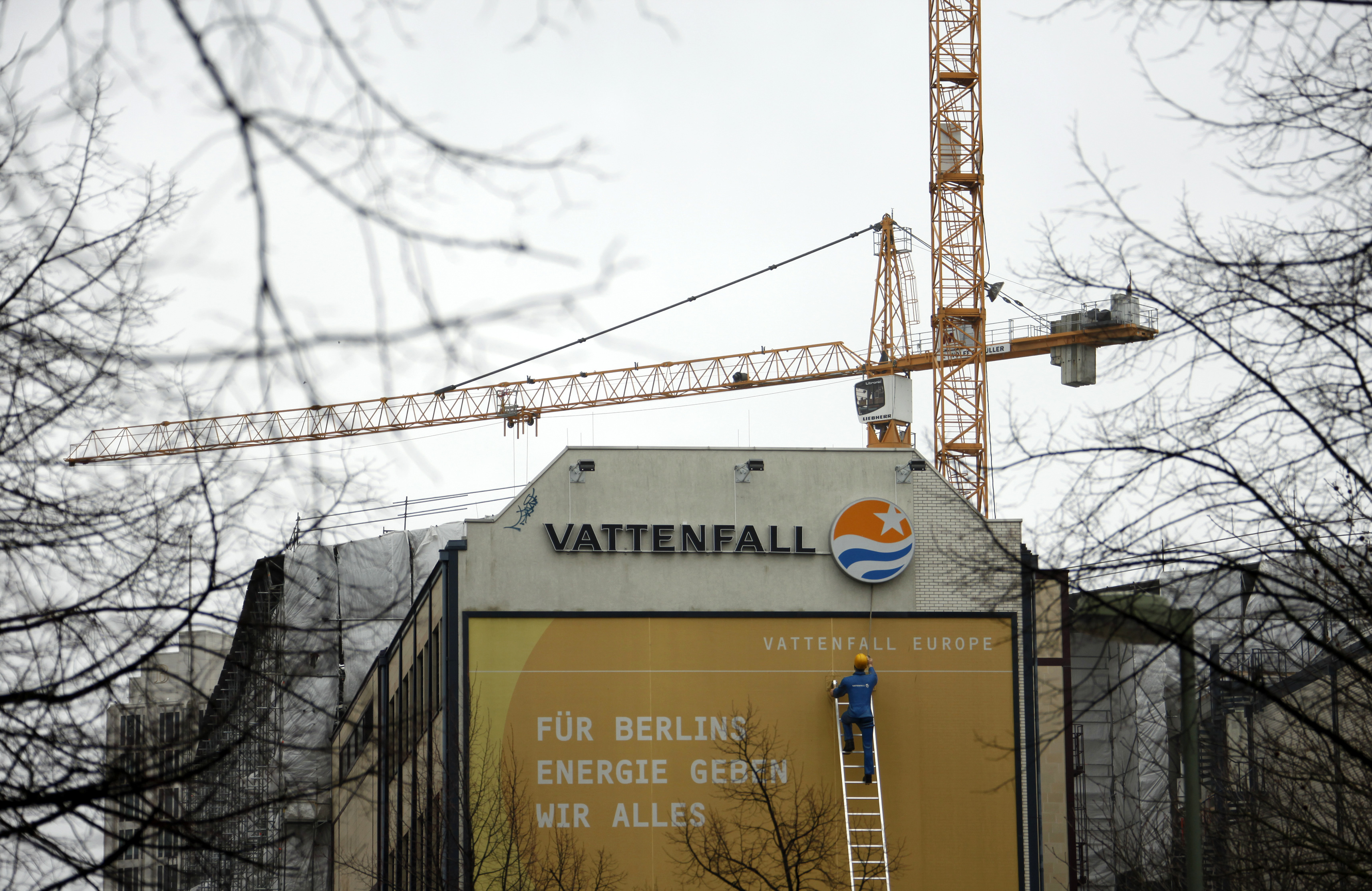 An advertisement of Vattenfall with figure of a worker on a long ladder climbing to a Vattenfall logo is pictured in Berlin
