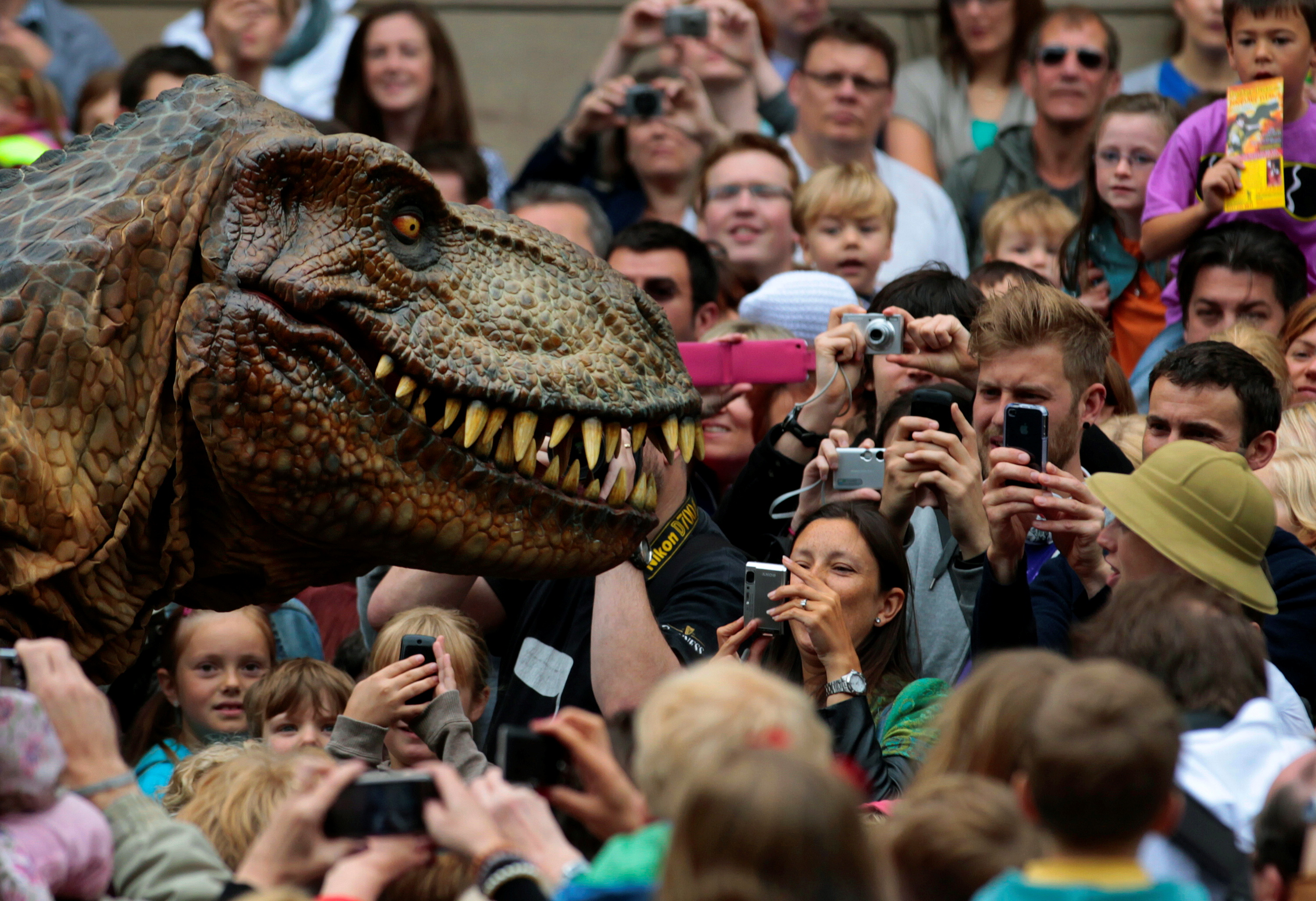 Visitors photograph an animatronic Tyrannosaurus rex at the reopening of the National Museum of Scotland in Edinburgh, Scotland July 29, 2011. REUTERS/David Moir