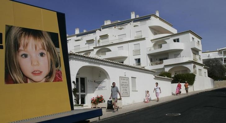 People walks near a billboard at Praia da Luz tourist resort